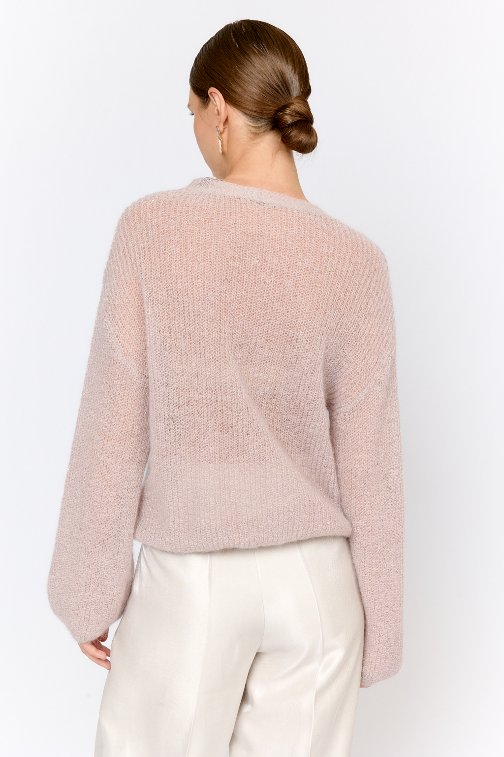 Кардиган с центральной застежкой на пуговицы, V-образной горловиной и длинным рукавом. Модель свободного силуэта в нежном пудровом оттенке из воздушной пряжи с шерстью и мохером с деликатными мелкими пайетками, придающими легкое сияние. Кардиган очень теплый, несмотря на свою трендовую транспарентность и легкость, благодаря мохеру в составе. Шерсть так же обеспечивает естественную терморегуляцию и уют. Такой кардиган будет выигрышно смотреться в образах с брюками и юбками из коллекции, а так же дополнит образы с платьями на бретелях или платьем-бандо.