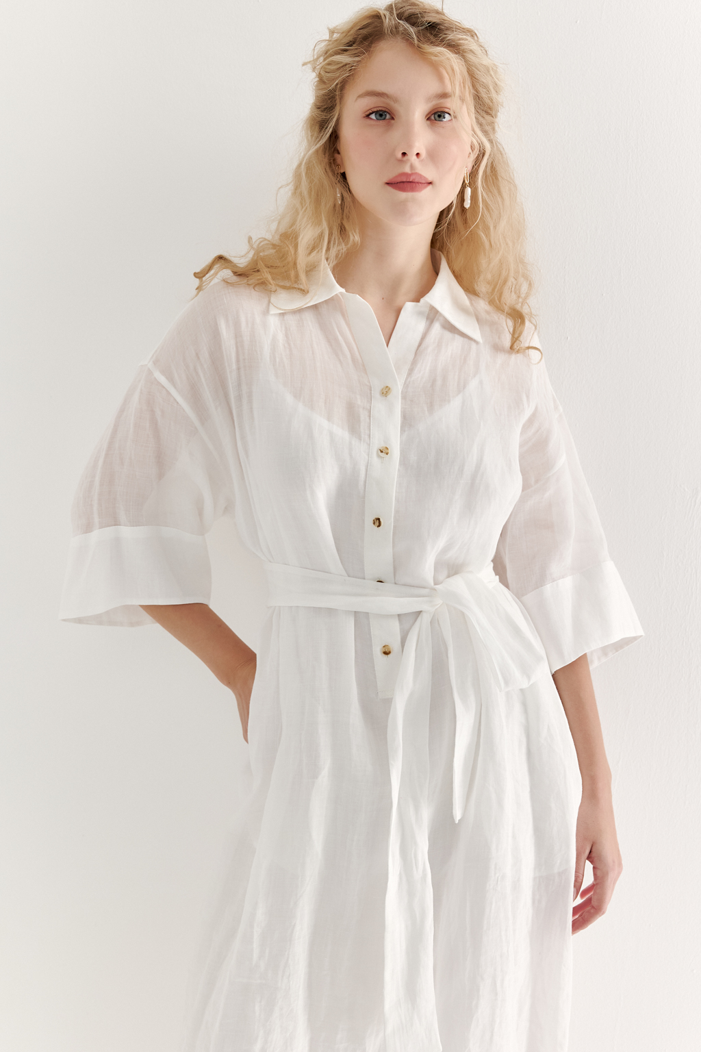 Это комфортное платье – традиционный образ для жаркого летнего дня. Платье изготовлено из воздушной невесомой вуали молочного цвета, в составе которой комфортный и экологичный материал крапива. Отложной воротник, планка для застежки, кокетка спинки, втачной широкий рукав одна вторая с отворотом, притачной бордюр по низу платья, пояс-самовяз и трапецивидный силуэт создают максимально комфортное образ. Возможно создание естственного крэш-эффекта, платье не требует сложного ухода.