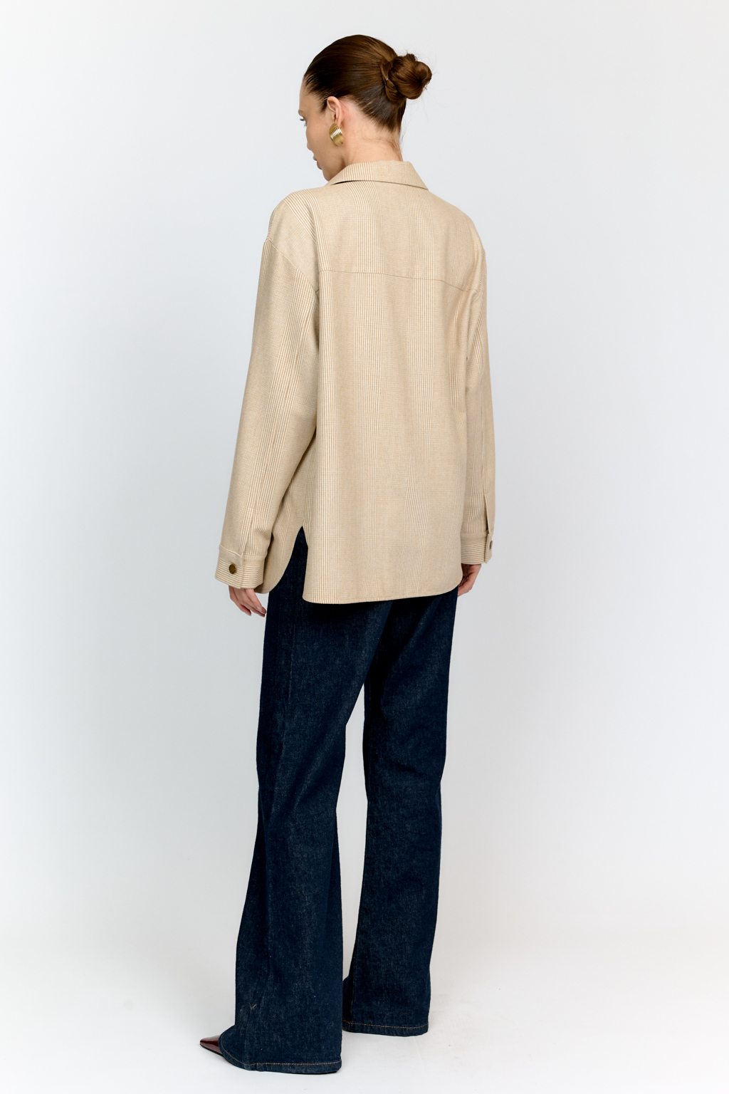 Рубашка свободного кроя с накладными карманами и застежкой на металлические пуговицы-болты из клетчатой костюмной ткани с peach-эффектом идеальна как для многослойных образов с футболками и водолазками, так и в качестве самостоятельной единицы.