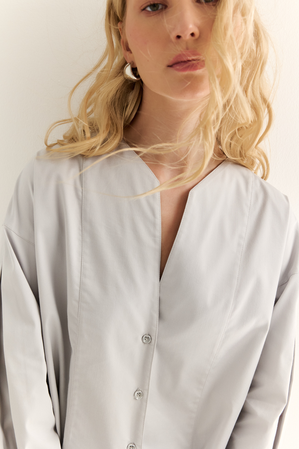 Блуза с V-вырезом: нежность в современном ритме. Эта блуза сочетает в себе деликатность форм и продуманную простоту. Глубокий V-образный вырез визуально вытягивает силуэт, а мягкие линии кокетки и рукавов добавляют романтичности. Объёмные рукава с манжетами и аккуратная застёжка на пуговицы завершают образ с лёгкой винтажной ноткой. Идеально смотрится в паре с юбками на высокой талии, широкими брюками или под жилет. Благодаря универсальному дизайну легко вписывается как в деловой, так и в вечерний гардероб. Лёгкость, которая подчёркивает внутреннюю силу.