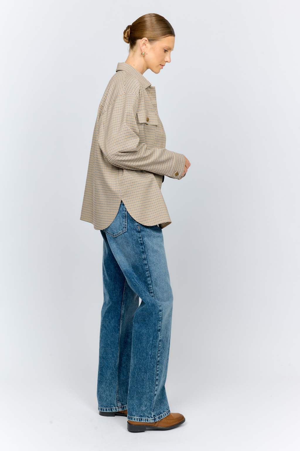 Рубашка свободного кроя с накладными карманами и застежкой на металлические пуговицы-болты из клетчатой костюмной ткани идеальна как для многослойных образов с футболками и водолазками, так и в качестве самостоятельной единицы.