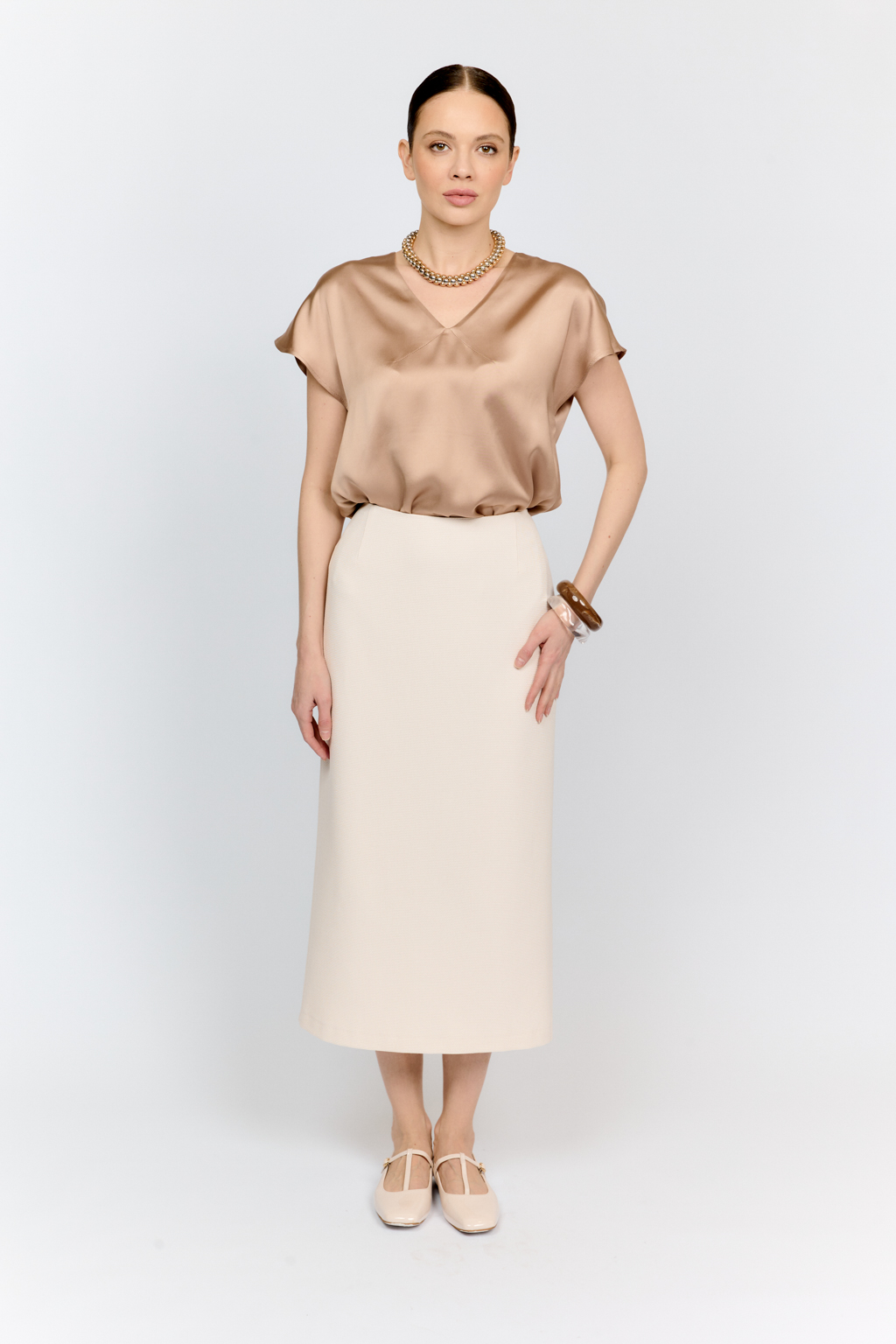 Топ с v-образным вырезом горловины из струящейся и переливающейся вискозы песочного цвета со спущенной линией плеча - отличная база для множества комплектов.