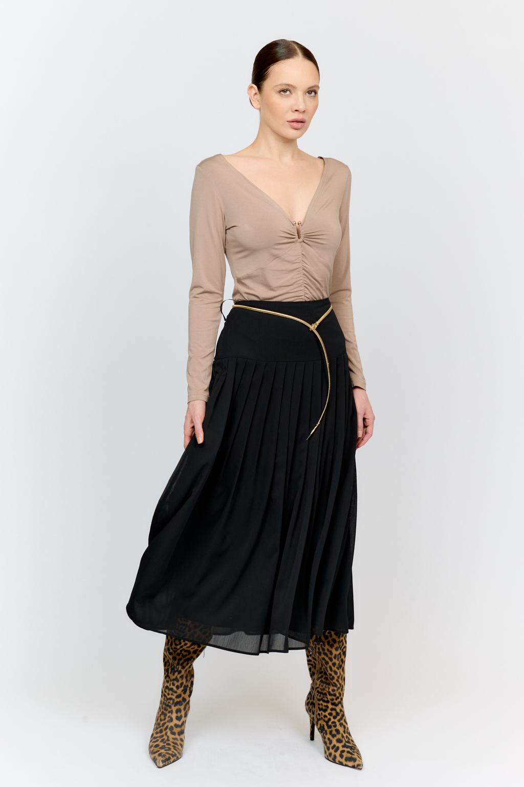 Лонгслив в цветет тофу с глубоким V-образным вырезом горловины и декором из металла в золотом оттенке. Спереди ткань драпируется в области груди и по средней линии полочки. Изделие подарит приятные тактильные ощущения в носке. Подойдет для стилизации со множеством образов.