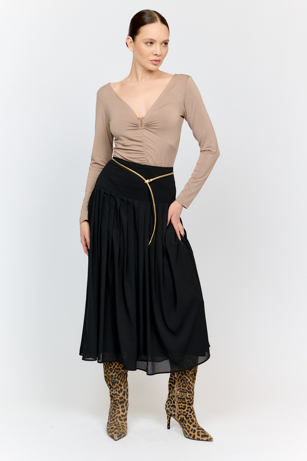 Лонгслив в цветет тофу с глубоким V-образным вырезом горловины и декором из металла в золотом оттенке. Спереди ткань драпируется в области груди и по средней линии полочки. Изделие подарит приятные тактильные ощущения в носке. Подойдет для стилизации со множеством образов.