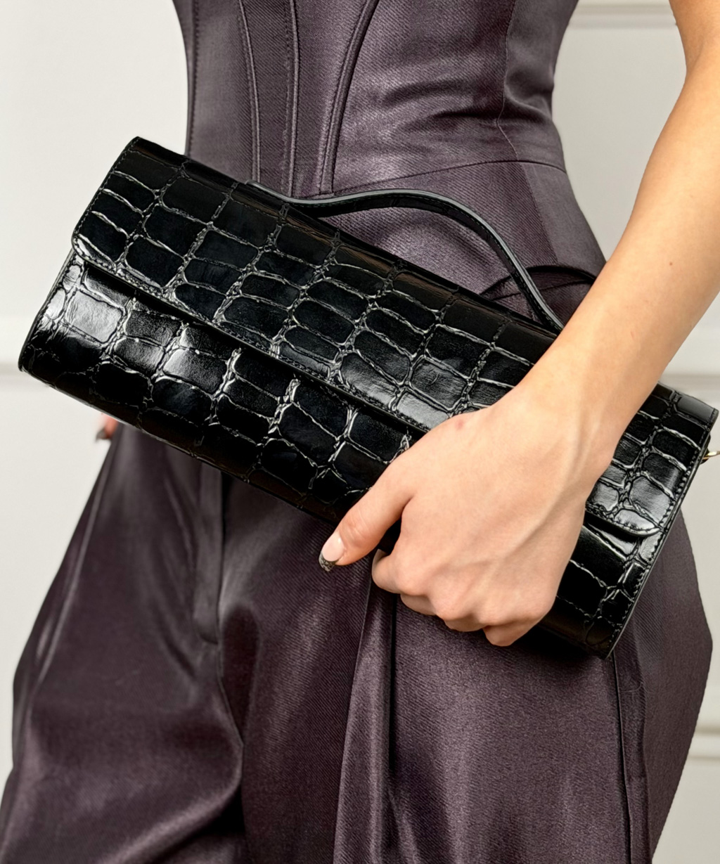 Сумка клатч выполнена из 100% натуральной кожи с тиснением под крокодил. Сочетание роскошной текстуры, практичности и элегантности для особых случаев. Надежная магнитная застежка обеспечивает безопасность и легкий доступ. Сумка имеет дополнительный регулируемый ремешок. Размеры сумки: 14*30*30 см