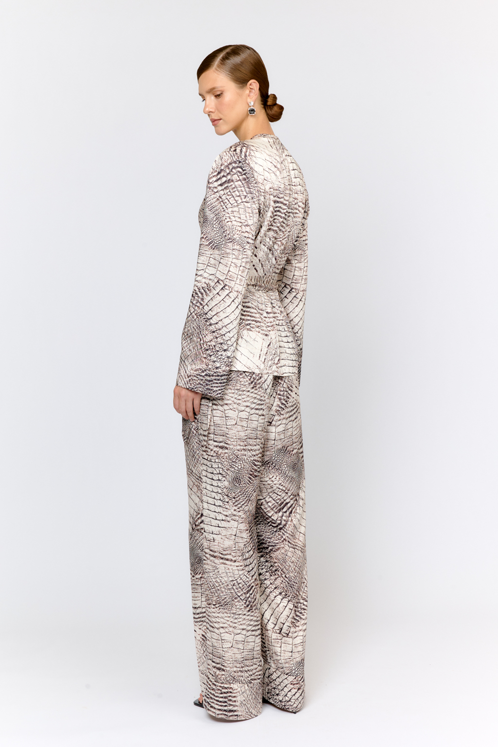 Брюки свободного силуэта с защипами с эластичным поясом на спинке . Свободный крой и струящаяся ткань делают модель комфортной в носке. Преимущества ткани: полиэстер добавляет прочности и практичности, сохраняя форму изделия. Ткань мягко драпируется, не сминается и не вытягивается, легкая и приятная на ощупь. Цветовое сочетание в дизайне принта позволяет комбинировать изделие с другими моделями коллекции.