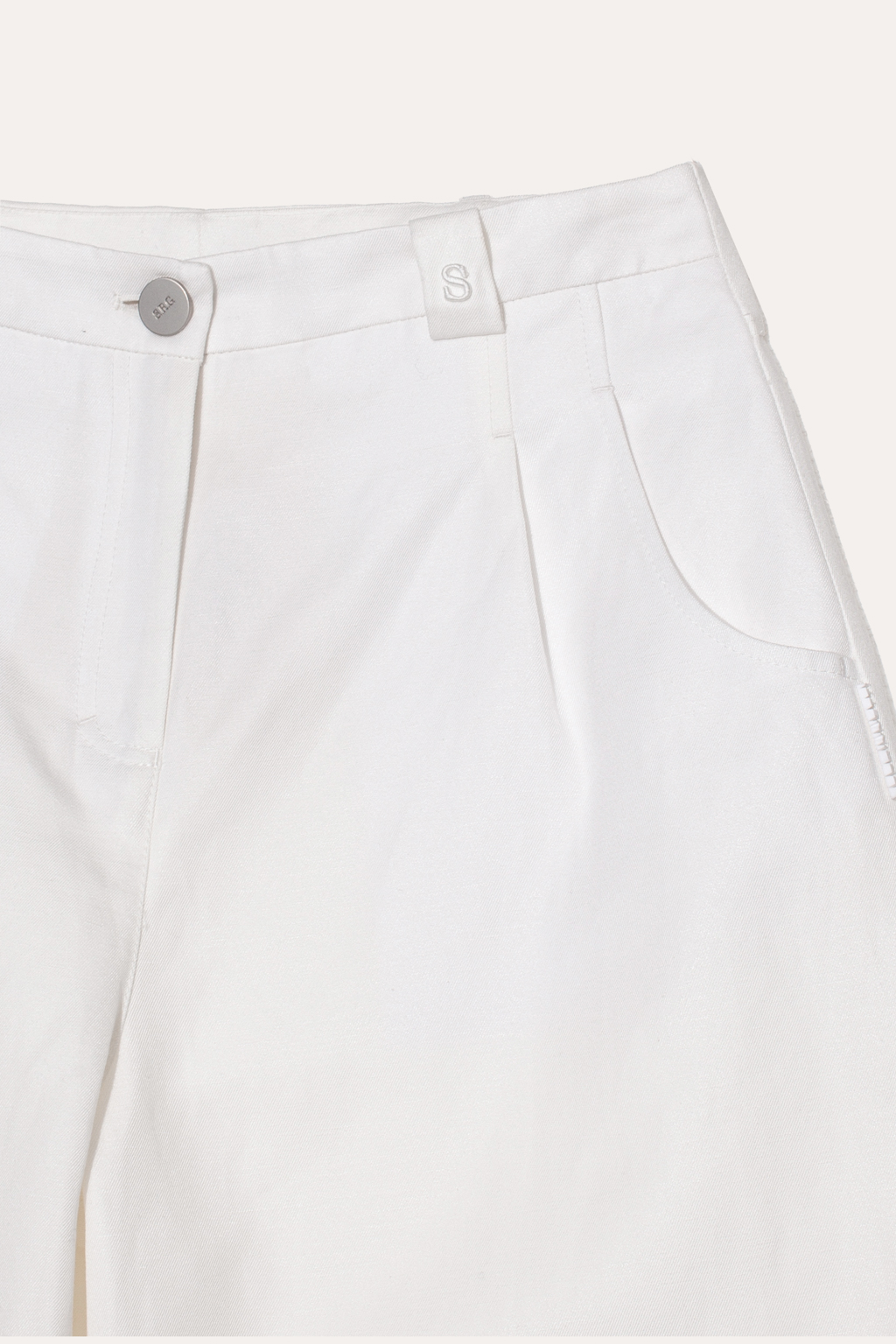 Джинсы свободного силуэта Barrel Leg – исключительное предложение этого сезона. Выполненные из хлопка и льна белого цвета, они расставляют безупречные акценты в образе, сочетая комфорт и стиль. Объемные в области бедер и чуть зауженные к низу.  Джинсы Barrel Leg с округлым силуэтом превосходно дополнят компактные трикотажные блузы, топы и льняные жакеты, создавая неповторимый образ. Одна из шлевок украшена изысканной 3D-вышивкой в виде литеры “S”-первой буквы названия бренда.