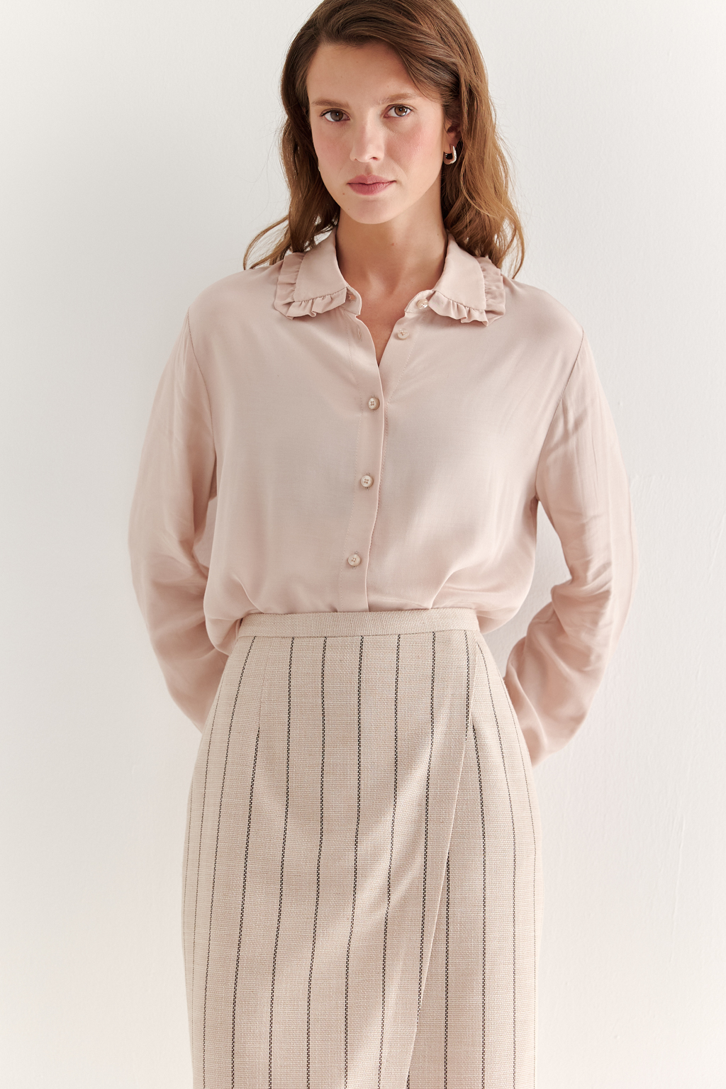 Прямая юбка с запахом выполнена из ткани, представляющей собой уникальную разработку бренда. Сочетание волокон хлопка, вискозы, полиэстера и эластана обеспечивает максимальный комфорт и практичность изделия. Нежный пудрово-розовый оттенок эффектно подчёркнут модной шоколадно-коричневой полоской в широком раппорте. Юбка идеально сочетается с жакетом архитектурного кроя из той же ткани, создавая завершённый формальный образ.