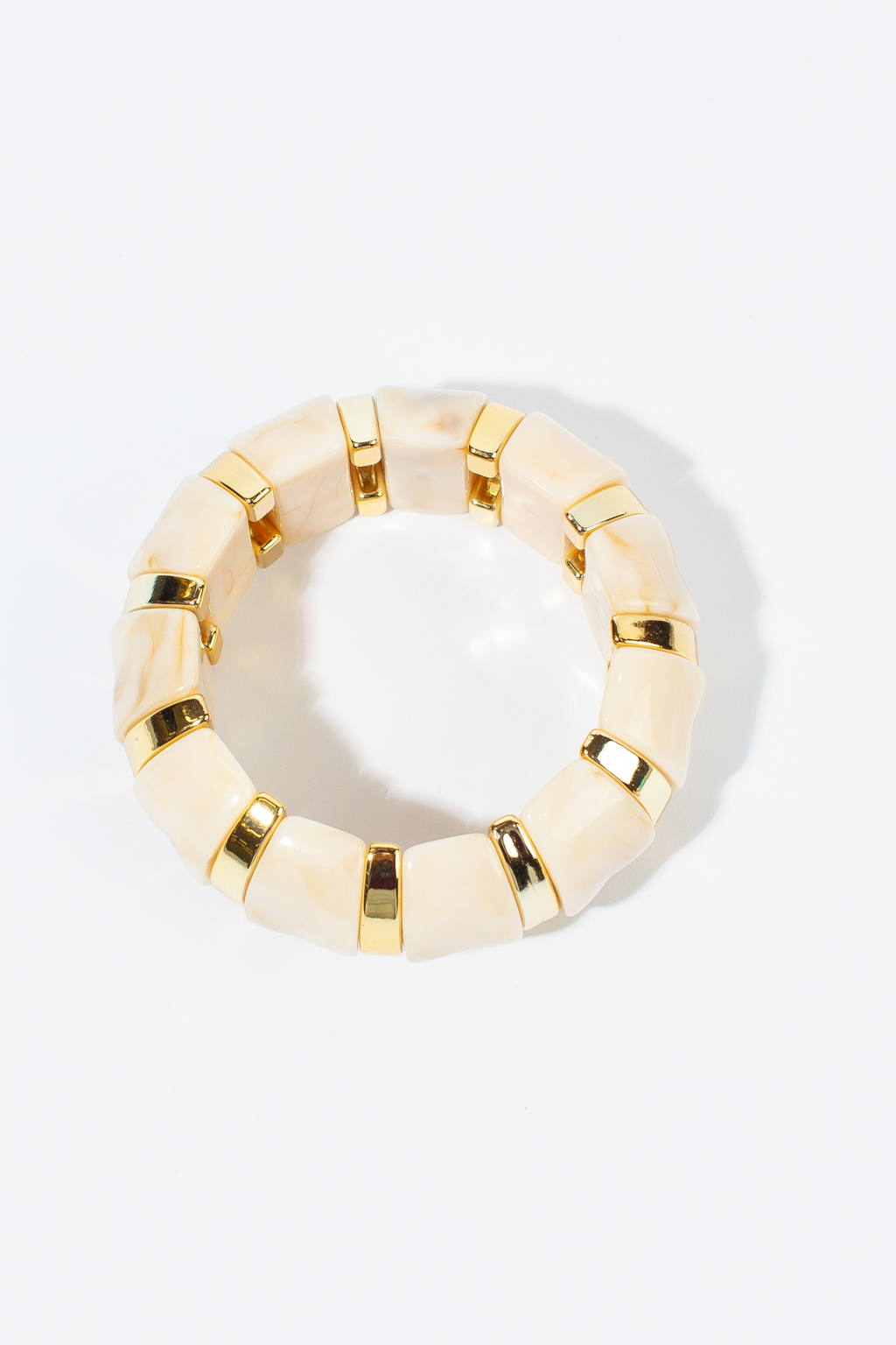 Стильный браслет в бежевом оттенке с золотыми вставками создан для женщин, ценящих неподвластный стиль времени. Изделие выполнено из акрилового ацетата, что обеспечивает его долговечность, легкость и современный дизайн. Крепление на резинке.