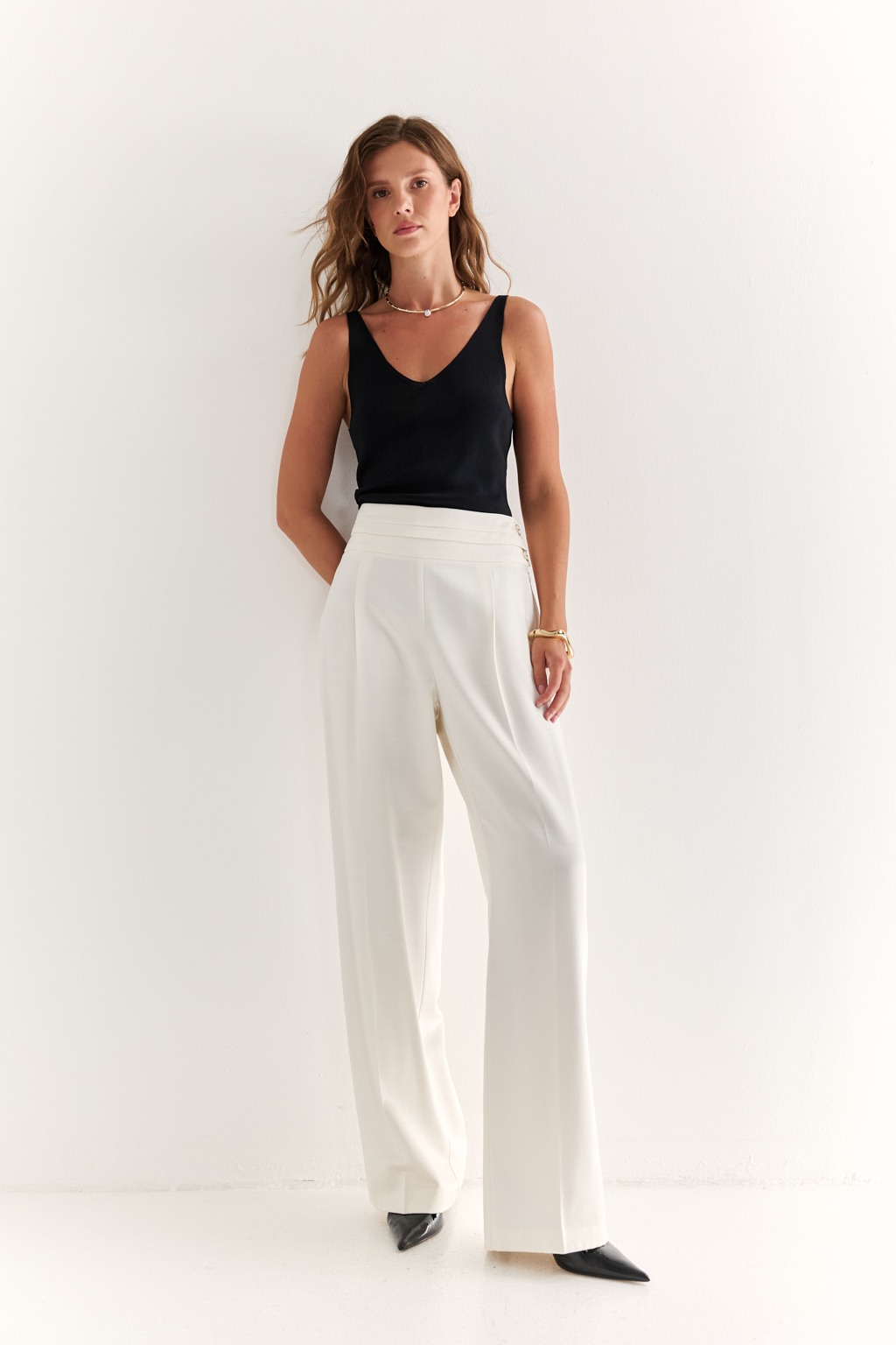 Брюки с боковой застёжкой: чистая линия и безупречная посадка
Эти брюки — воплощение утончённого минимализма. Высокая посадка подчёркивает талию, а скрытая боковая застёжка на молнию и пуговицы сохраняет идеальную гладкость передней линии, визуально вытягивая силуэт.
Прямой крой и плотная, хорошо держащая форму ткань создают стройный и элегантный образ. Широкий пояс анатомической формы обеспечивает комфортную посадку и подчёркивает женственность.
Идеальны в комплекте с жакетом или шелковой блузой, а также легко адаптируются под повседневный образ с базовой рубашкой или топом.
Брюки, которые подчеркивают вкус без лишних слов.
