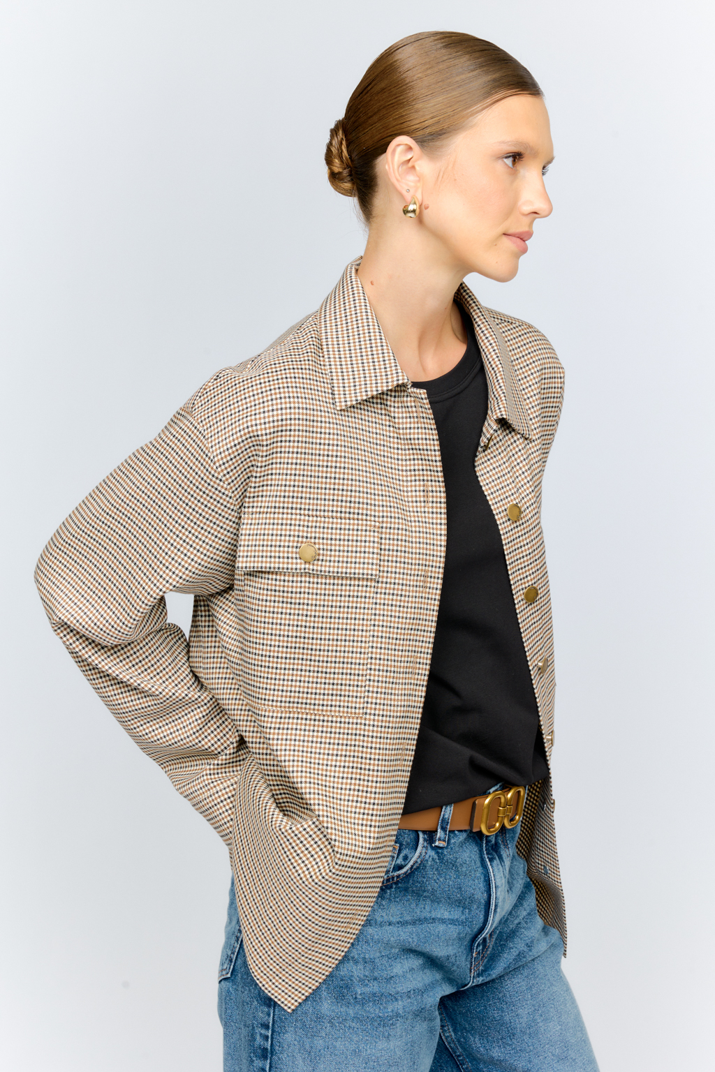 Рубашка свободного кроя с накладными карманами и застежкой на металлические пуговицы-болты из клетчатой костюмной ткани идеальна как для многослойных образов с футболками и водолазками, так и в качестве самостоятельной единицы.