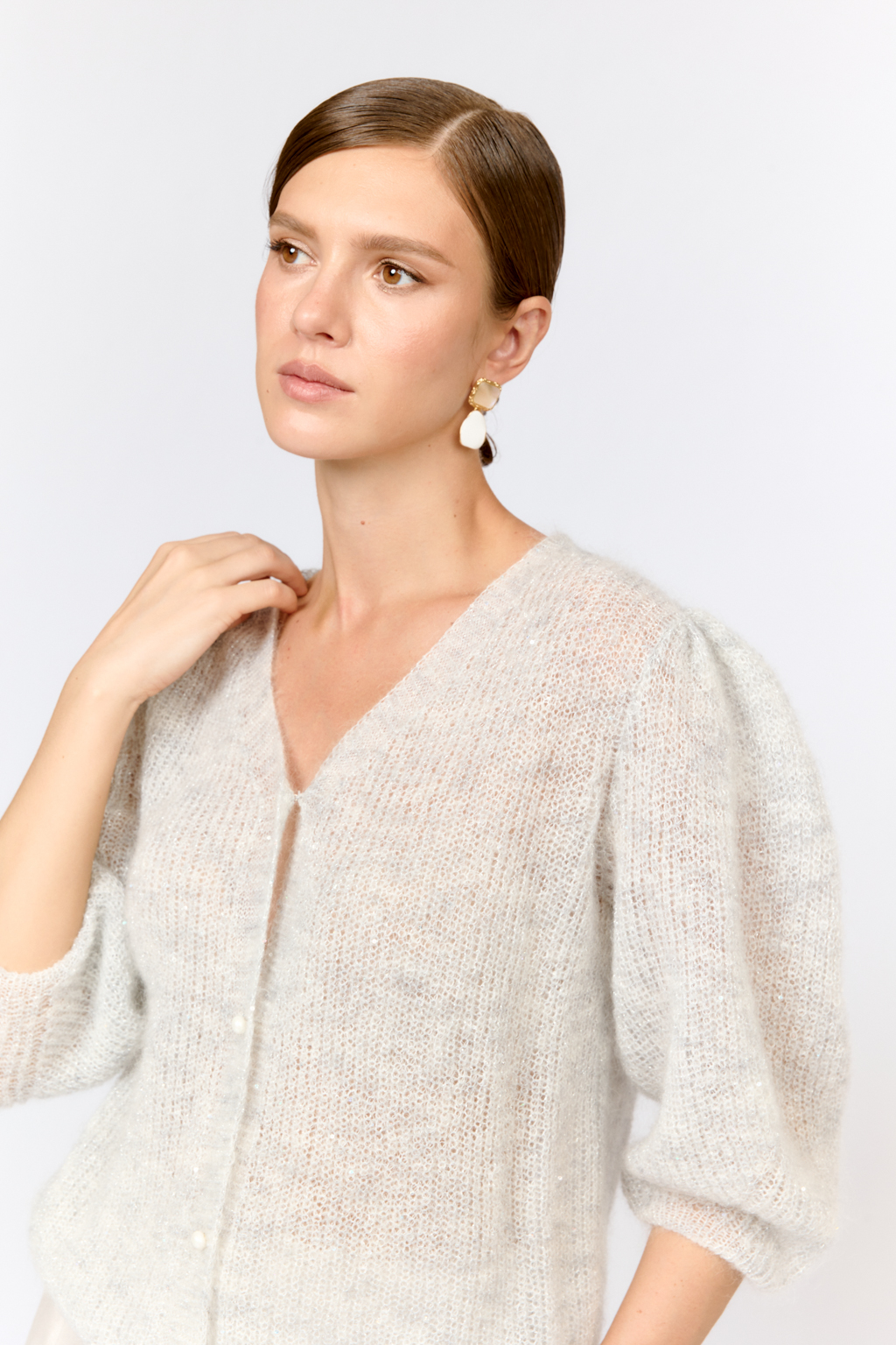 Легкий кардиган с центральной застежкой на пуговицы, V-образной горловиной и укороченным рукавом. Выполнен в премиальной пряже в составе которой, мохер и шерсть. Невесомый на вид, кардиган теплый и уютный. Мохер обладает множеством преимуществ: он легкий, обладает натуральным блеском, прочностью и долговечностью, отлично удерживает тепло. Кроме того, мохер устойчив к скатыванию и деформации. Модель кардигана умеренного объема с укороченным рукавом, идеальна для вечерних образов.