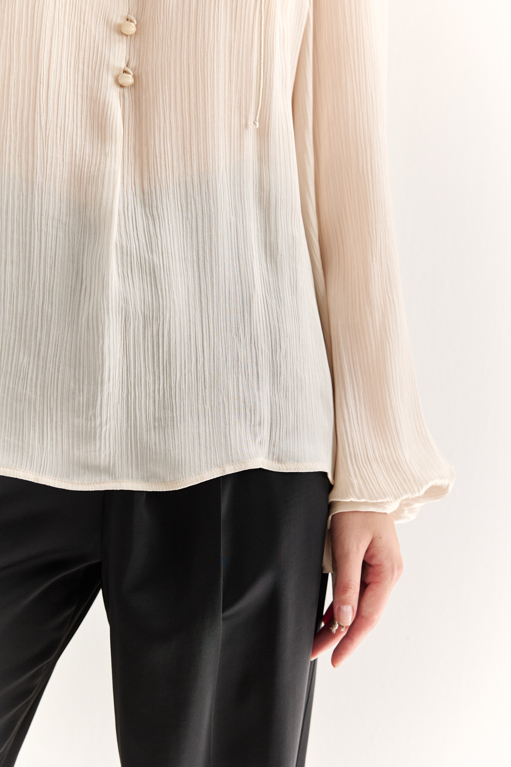 Блуза из 100% шёлка: воздушная элегантность с характером. Эта блуза создана из натурального шёлка — благородной ткани, которая буквально скользит по коже и придаёт образу утончённость. Объёмные рукава с  завязками создают лёгкий силуэт, а мягкая рюша по линии горловины добавляет динамики и изящества. Прямой крой обеспечивает комфорт и универсальность: блуза легко адаптируется под офисный стиль, романтичные образы или вечерние выходы. Носите с классическими брюками, юбками или джинсами — она всегда выглядит достойно. Чистый шёлк. Чистая элегантность.