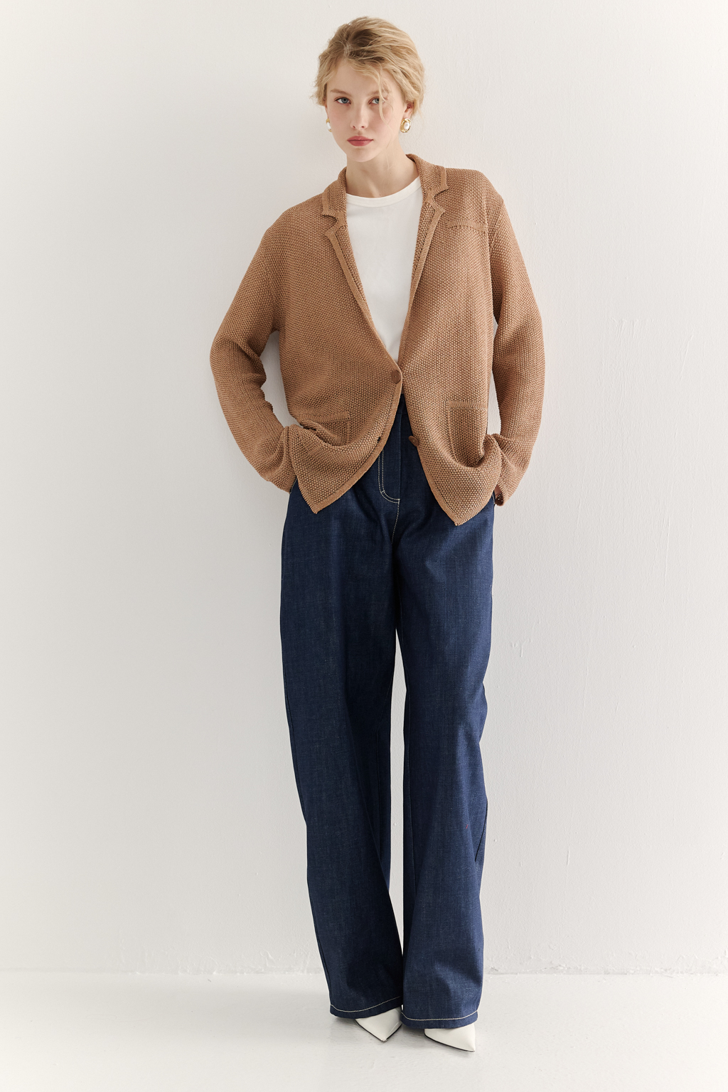 Жакет полуприлегающего силуэта  цвета бронзы из вязанного трикотажа, в составе которого вискоза и хлопок. Плотная скрутка нити образует упругое, но в то же время дышащее полотно. Цельно вязаные лацканы элегантно переходят в воротник, обрамляя вырез. Прямые рукава полной длины завершают лаконичный силуэт. Этот жакет станет изысканным дополнением к непринужденному городскому образу.