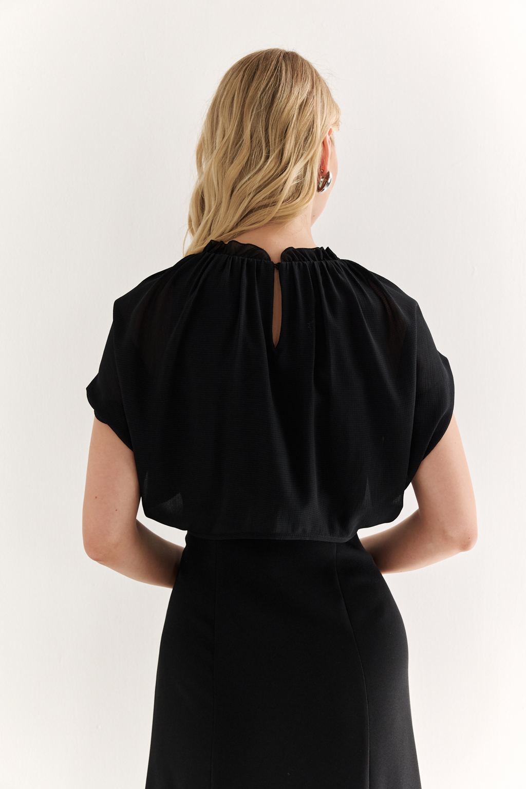 Платье с эффектом лепестков и шифоновой драпировкой: утончённая женственность в движении

Это платье словно создано для того, чтобы подчеркнуть красоту силуэта и придать образу воздушности. Драпировка на плечах из полупрозрачного шифона формирует эффект лепестков, мягко окутывая верх и придавая образу лёгкость, загадочность и изысканность.

Приталенный крой с расклешённой нижней частью визуально вытягивает фигуру и подчёркивает талию. Шифон не только добавляет деликатной динамики, но и создаёт выразительный контраст с плотной основной тканью, подчеркивая архитектуру платья.

Идеально подойдёт для вечерних выходов, приёмов и особых событий, где важна не только элегантность, но и уникальность подачи.

Воздушная графика. Платье, в котором ткань говорит языком чувственности.