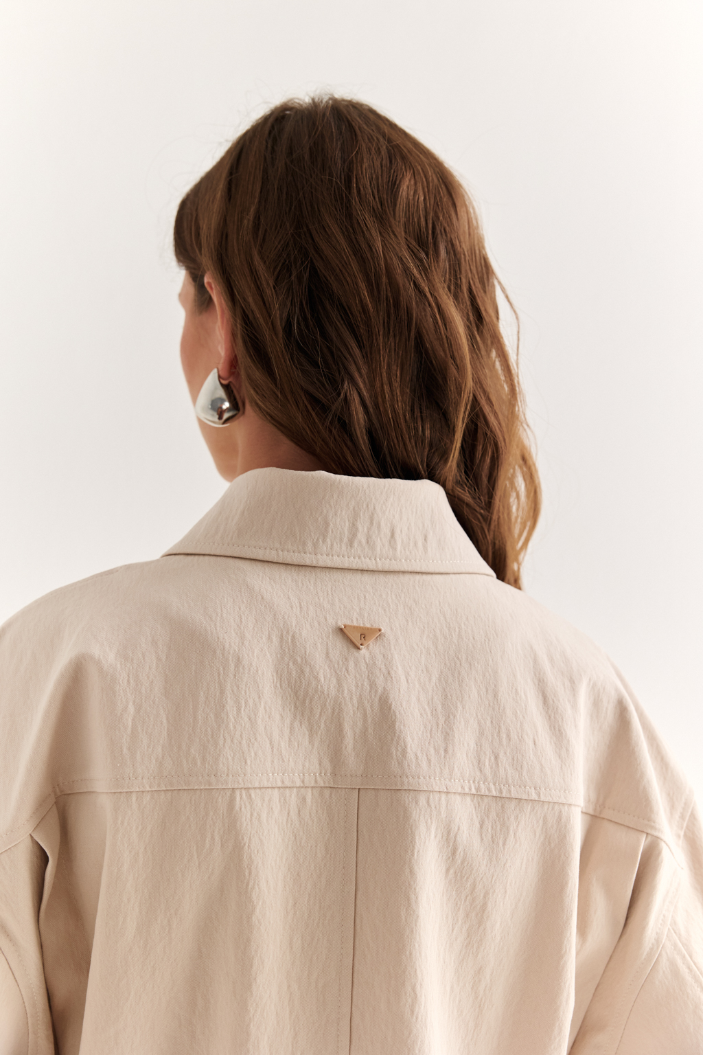Куртка прямого силуэта длиной до бедер и с кулисой по талии. Воротник рубашечный, застежка под планкой. По полочке накладные карманы-портфели.