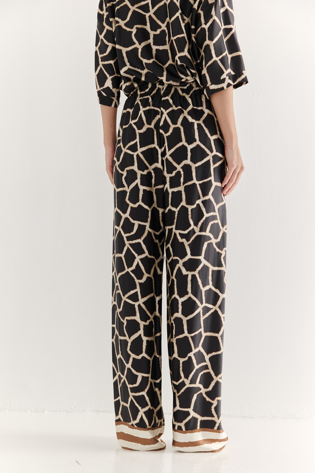 Брюки, широкие и прямые по всей длине, выполнены из полированной вискозы с шелковистой текстурой, украшена эксклюзивным анималистическим принтом, разработанным дизайнерами бренда. Основной тренд - создание атмосферы комфорта, пронизанной заботой и бережным отношением к себе. Брюки оснащены удобными карманами и эластичным поясом, обеспечивающими максимальный комфорт и удобство. По низу брюк – контрастный по цвету бордюр. Идеальным дополнением к этим брюкам станут блуза из той же коллекции, а так же объёмный трикотажный кардиган.