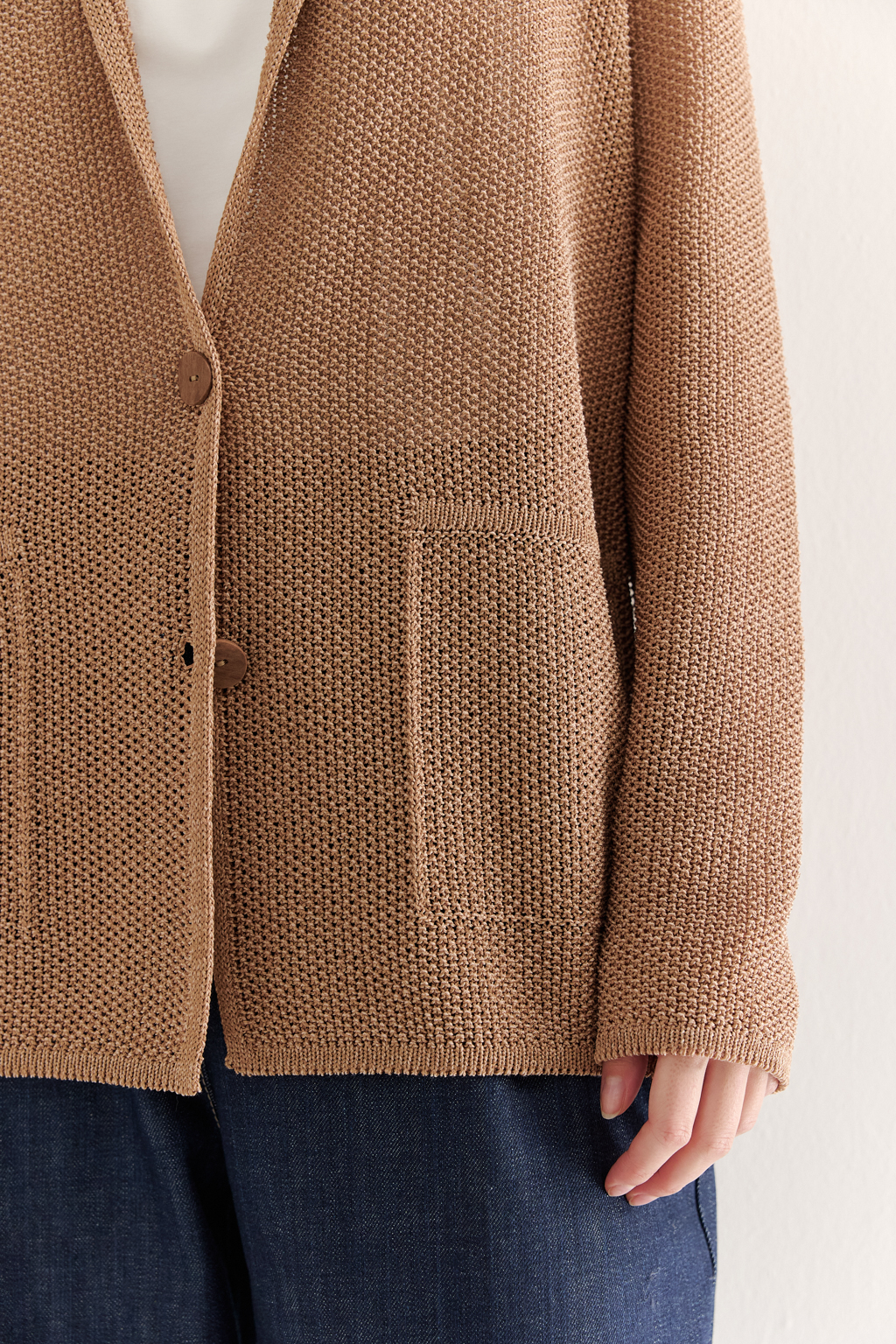 Жакет полуприлегающего силуэта  цвета бронзы из вязанного трикотажа, в составе которого вискоза и хлопок. Плотная скрутка нити образует упругое, но в то же время дышащее полотно. Цельно вязаные лацканы элегантно переходят в воротник, обрамляя вырез. Прямые рукава полной длины завершают лаконичный силуэт. Этот жакет станет изысканным дополнением к непринужденному городскому образу.