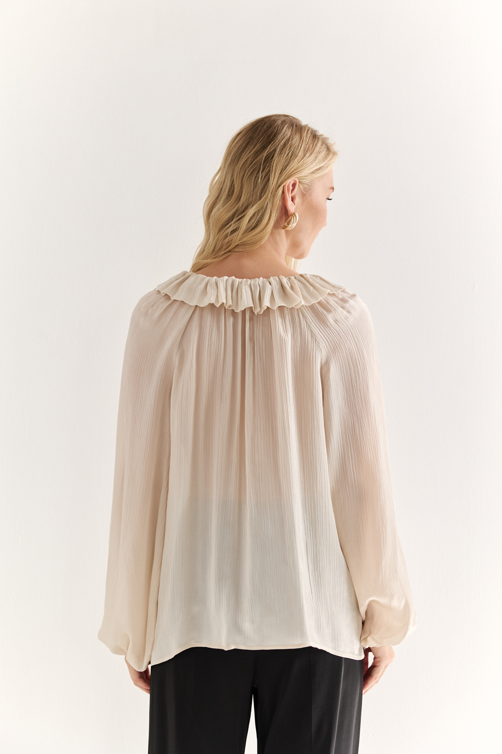 Блуза из 100% шёлка: воздушная элегантность с характером. Эта блуза создана из натурального шёлка — благородной ткани, которая буквально скользит по коже и придаёт образу утончённость. Объёмные рукава с  завязками создают лёгкий силуэт, а мягкая рюша по линии горловины добавляет динамики и изящества. Прямой крой обеспечивает комфорт и универсальность: блуза легко адаптируется под офисный стиль, романтичные образы или вечерние выходы. Носите с классическими брюками, юбками или джинсами — она всегда выглядит достойно. Чистый шёлк. Чистая элегантность.