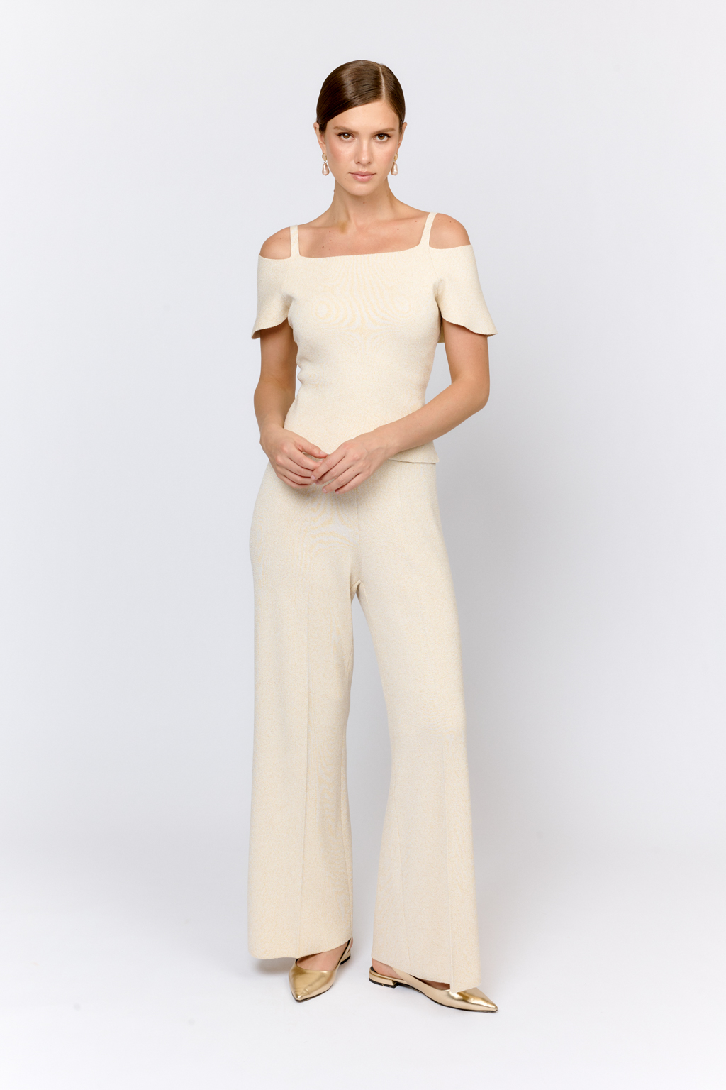 Топ на бретелях с открытыми плечами и пелериной. Оригинальный дизайн модели, подчеркивающий линию декольте и плечи воплощен в приятном к телу материале с вискозой в элегантном молочно-золотом цвете. Топ можно комбинировать с юбкой  или брюками из аналогичного материала. Или сочетать в образах с текстильными брюками из коллекции.