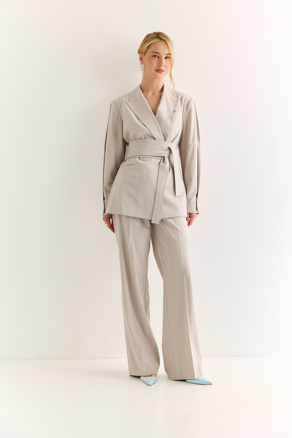 Жакет с поясом-кушаком: мягкая сила и подчёркнутая линия. Этот жакет сочетает в себе структурированную форму и пластичность драпировки. Приталенный силуэт акцентирован широким поясом-кушаком, который завязывается на талии, формируя выразительную линию «песочных часов» и добавляя образу женственности без излишней строгости.
Острые лацканы, аккуратная линия плеч и выверенный крой рукавов делают модель универсальной: для делового дня, кэжуал-комплекта или вечернего выхода. Пояс, завязанный на узел или бант, задаёт настроение и подчеркивает индивидуальность. Гармония формы и мягкости. Жакет, который раскрывает силу через утончённость.