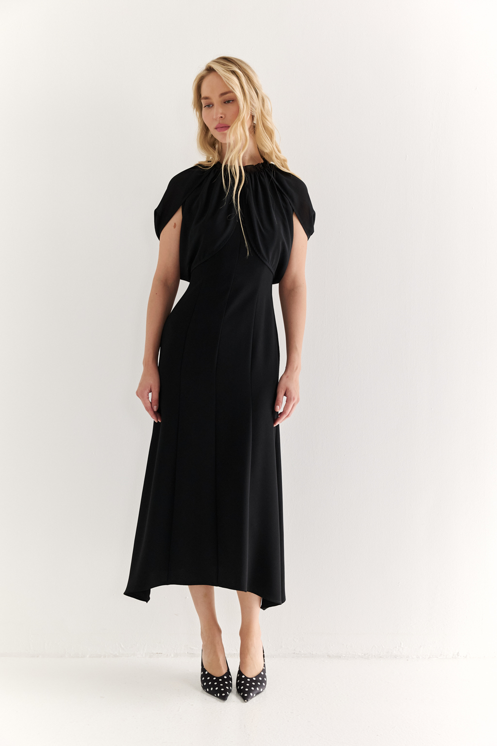 Платье с эффектом лепестков и шифоновой драпировкой: утончённая женственность в движении

Это платье словно создано для того, чтобы подчеркнуть красоту силуэта и придать образу воздушности. Драпировка на плечах из полупрозрачного шифона формирует эффект лепестков, мягко окутывая верх и придавая образу лёгкость, загадочность и изысканность.

Приталенный крой с расклешённой нижней частью визуально вытягивает фигуру и подчёркивает талию. Шифон не только добавляет деликатной динамики, но и создаёт выразительный контраст с плотной основной тканью, подчеркивая архитектуру платья.

Идеально подойдёт для вечерних выходов, приёмов и особых событий, где важна не только элегантность, но и уникальность подачи.

Воздушная графика. Платье, в котором ткань говорит языком чувственности.