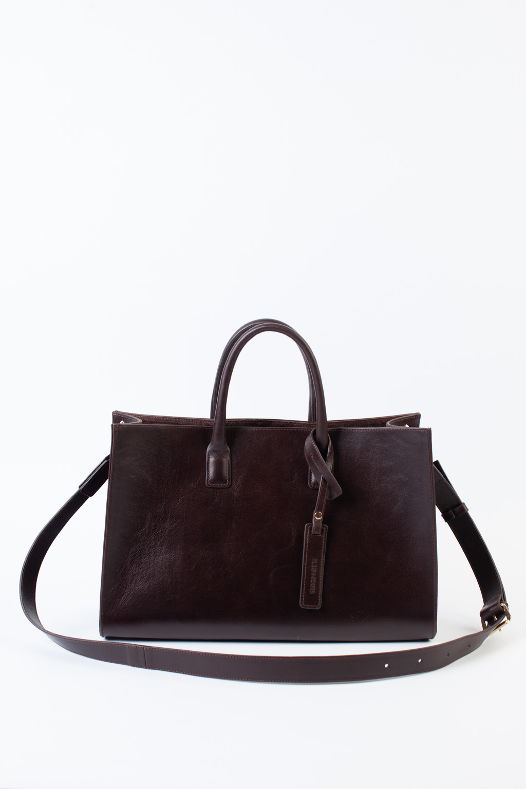 Стильная сумка через плечо глубокого шоколадного оттенка станет незаменимым спутником вашей коллекции. Простая, лаконичная форма идеально впишется в деловой образ. Вместительная модель выполнена из натуральной гладкой кожи с ручками сверху и дополнена ремешком через плечо. Размеры сумки: 39,7*25*14 см.