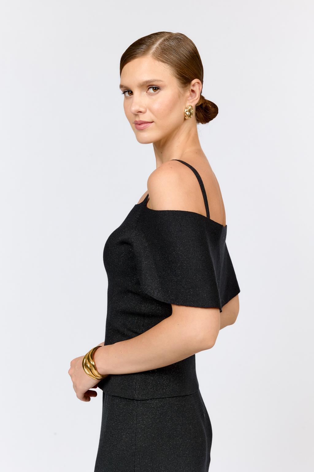 Топ на бретелях с открытыми плечами и пелериной. Качественный материал с эластаном и вискозой, классический черный цвет позволяет создавать образы на каждый день. Сочетайте с классическими брюками или юбками трапециями, джинсами для создания гармоничного комплекта.