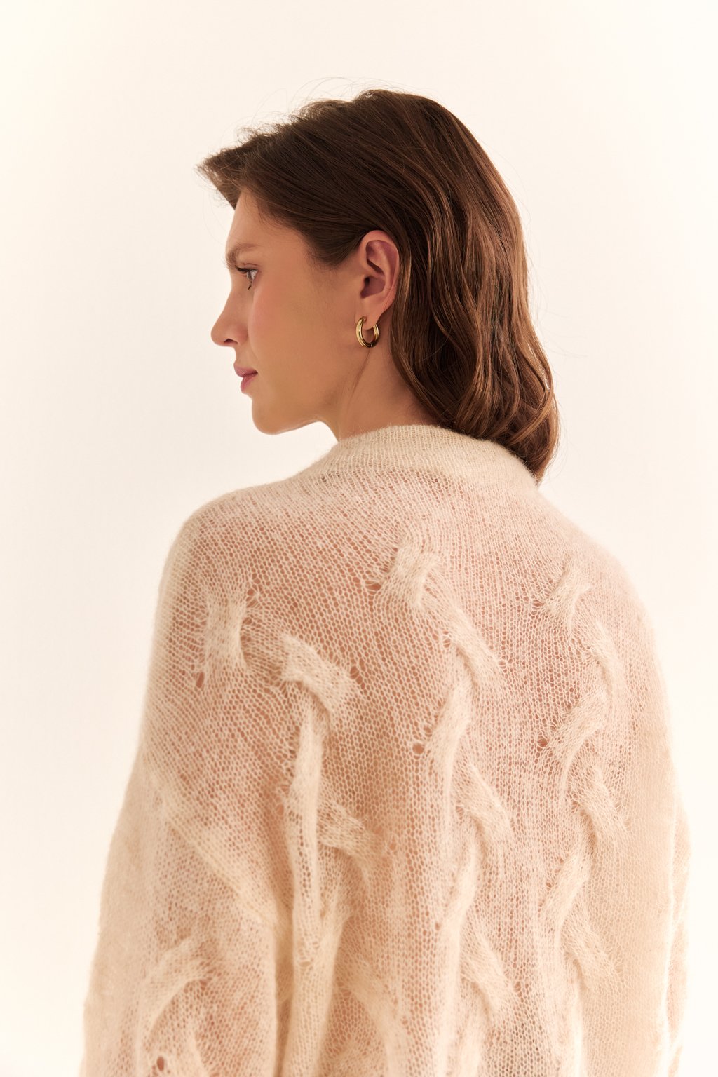 Джемпер-паутинка с фактурными перехлестами и цельновязанной стойкой.Воздушный джемпер-паутинка, воплощающий эстетику невесомой элегантности и тактильного комфорта. Ажурное, полупрозрачное полотно с тонкими фактурными перехлестами создает сложную, изящную структуру, напоминающую узор «косы». Цельновязанный воротник-стойка добавляет модели лаконичную завершенность и уют, мягко обрамляя шею.Преимущества состава и детали вязки:Джемпер выполнен из уникальной пряжи, где каждый компонент отвечает за ключевые свойства изделия:Кид мохер — создаёт характерную лёгкую, воздушную дымку вокруг нити, обеспечивая невесомую пушистость, благородный объём и исключительную мягкость. Этот компонент придает джемперу деликатный ворсистый силуэт и тактильный комфорт высшего уровня.Шерсть — является основой, отвечающей за тепло, эластичность и способность полотна сохранять форму. Натуральное волокно обеспечивает естественную терморегуляцию, дышит и придает упругость.Нейлон — выступает прочной основой, которая многократно повышает износостойкость ажурного полотна, предотвращает деформацию и растягивание сложных перехлестов. Он гарантирует, что тонкая структура «паутинки» надолго сохранит свою изящную форму.Детали:— Сложное ажурное вязаное полотно «паутинка»— Фактурные перехлесты, образующие рельефный узор— Цельновязанный воротник-стойка— Невесомая, пушистая фактураС чем носить:Прекрасно дополнит брюки, юбки-миди. Создаст эффектный контраст с кожаными юбками, брюками и плотными денимовыми куртками.Этот джемпер — образец высокого вязального мастерства, где сложный ажур, уникальный состав и безупречный комфорт создают выразительный, утончённый и по-настоящему особенный элемент гардероба.