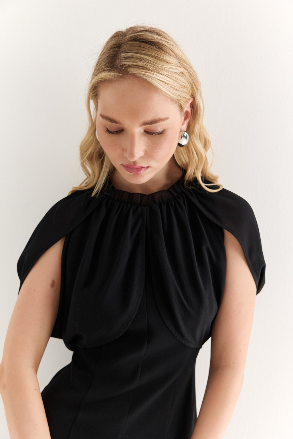 Платье с эффектом лепестков и шифоновой драпировкой: утончённая женственность в движении

Это платье словно создано для того, чтобы подчеркнуть красоту силуэта и придать образу воздушности. Драпировка на плечах из полупрозрачного шифона формирует эффект лепестков, мягко окутывая верх и придавая образу лёгкость, загадочность и изысканность.

Приталенный крой с расклешённой нижней частью визуально вытягивает фигуру и подчёркивает талию. Шифон не только добавляет деликатной динамики, но и создаёт выразительный контраст с плотной основной тканью, подчеркивая архитектуру платья.

Идеально подойдёт для вечерних выходов, приёмов и особых событий, где важна не только элегантность, но и уникальность подачи.

Воздушная графика. Платье, в котором ткань говорит языком чувственности.