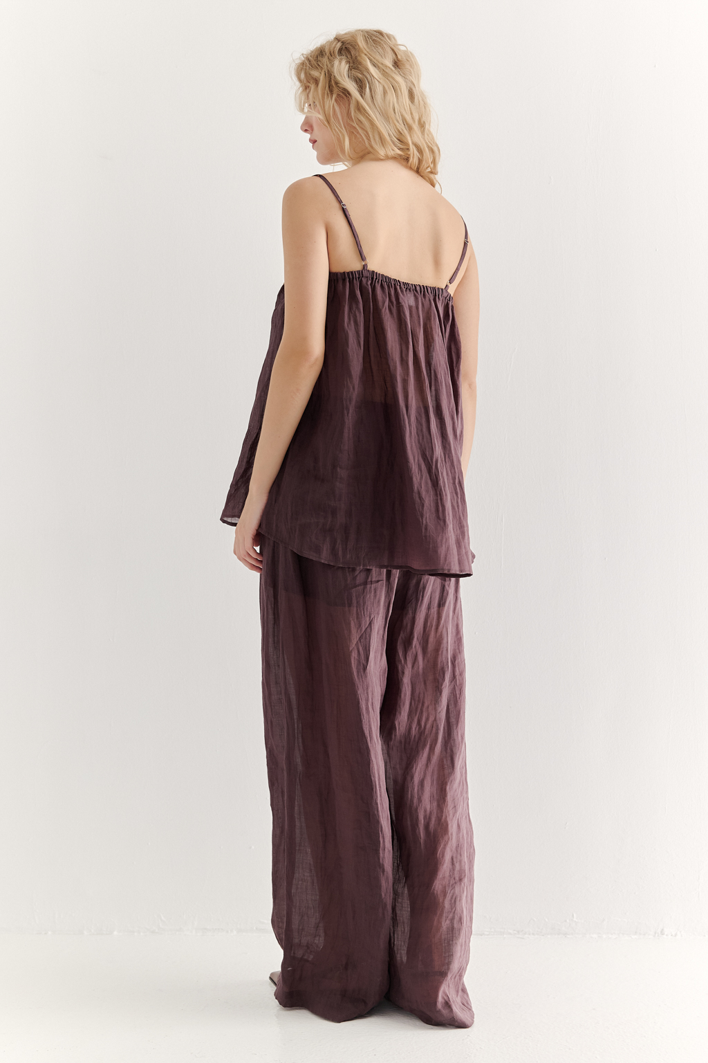 Топ-трапеция, выполненный из стопроцентной крапивы с крэш-эффектом благородного коричневого оттенка, украшен отделкой из кружевного гипюра нежного бежевого цвета. Кружевная деталь изысканно располагается на передней части изделия. Деталь переда топа настрочены на кружево со сборкой, по верхнему срезу спинки предусмотрена резинка, обеспечивающая оптимальную посадку. Бретели топа регулируются. Топ представляет собой идеальный комплект с брюками из крапивы, льна или хлопка, создавая гармоничный и стильный образ