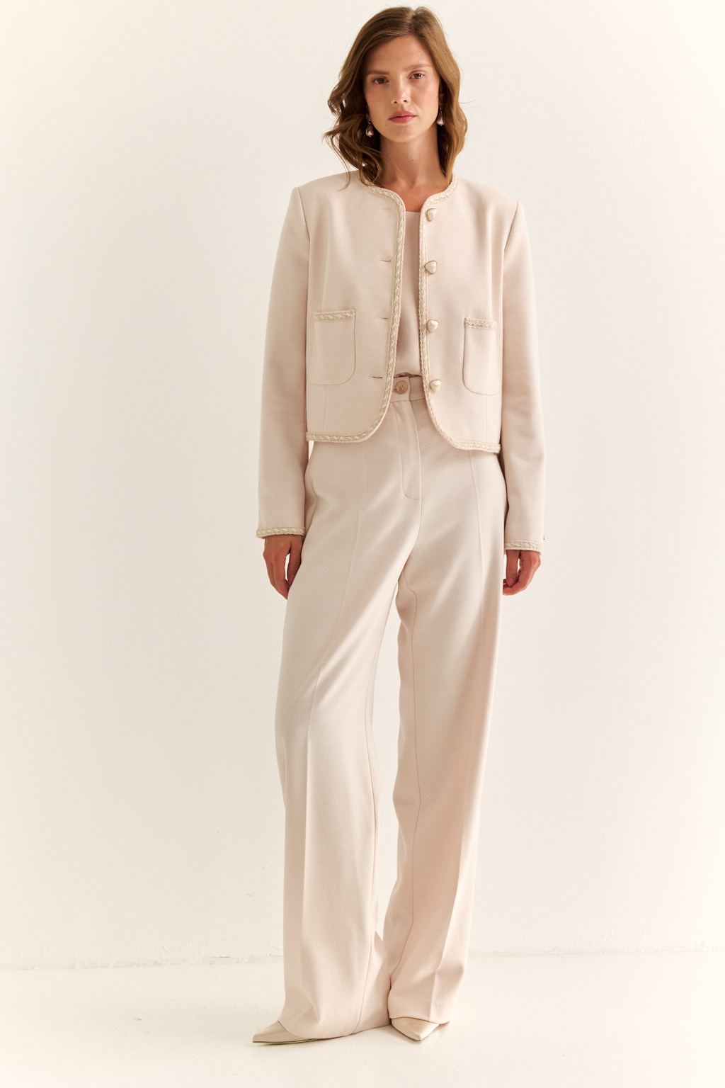 Жакет в стиле Chanel: вечная классика с характером. Икона женственности в новом прочтении — жакет в стиле Chanel с характерными элементами: округлым вырезом, выразительной декоративной тесьмой и крупными акцентными пуговицами. Прямой укороченный силуэт подчёркивает линию талии и делает модель идеальной как для офисного образа, так и для изысканного вечера. Накладные карманы добавляют практичности и шарма, а отделка по борту и рукавам формирует изящную рамку силуэта. Носите с юбкой, джинсами или брюками — он добавит статусности в любой комплект. Легендарный силуэт. Современное звучание.