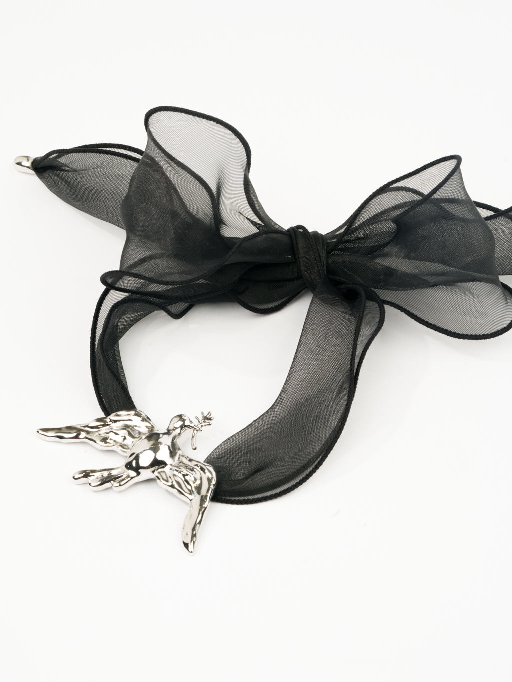 Дизайнерское колье из коллекции «SERENITY» с металлическим кулоном в виде летящей птицы серебряного цвета на текстильной ленте из черной плотной органзы. Длина ленты позволяет варьировать стиль колье. Украшение выполнено из гипоаллергенного сплава с гальваническим покрытием. Колье прекрасно сочетается как с платьями, так и с жакетами.  Вес колье составляет 39 гр, длина до 140 см.