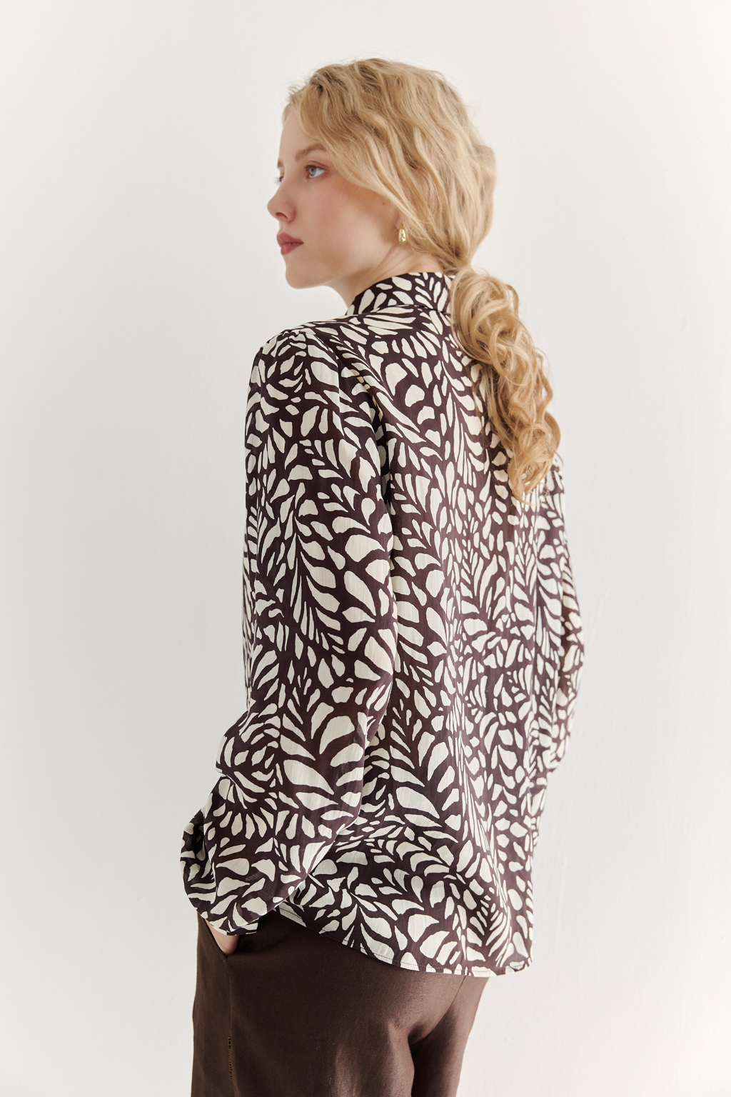 Блуза из легкой блузочной ткани с эффектом шелка со стилизованным растительным принтом в шоколадно-молочной гамме. Комфортная блуза имеет рубашечный воротник со стойкой, длинный рукав с манжетами, застёгивается на пуговицы.