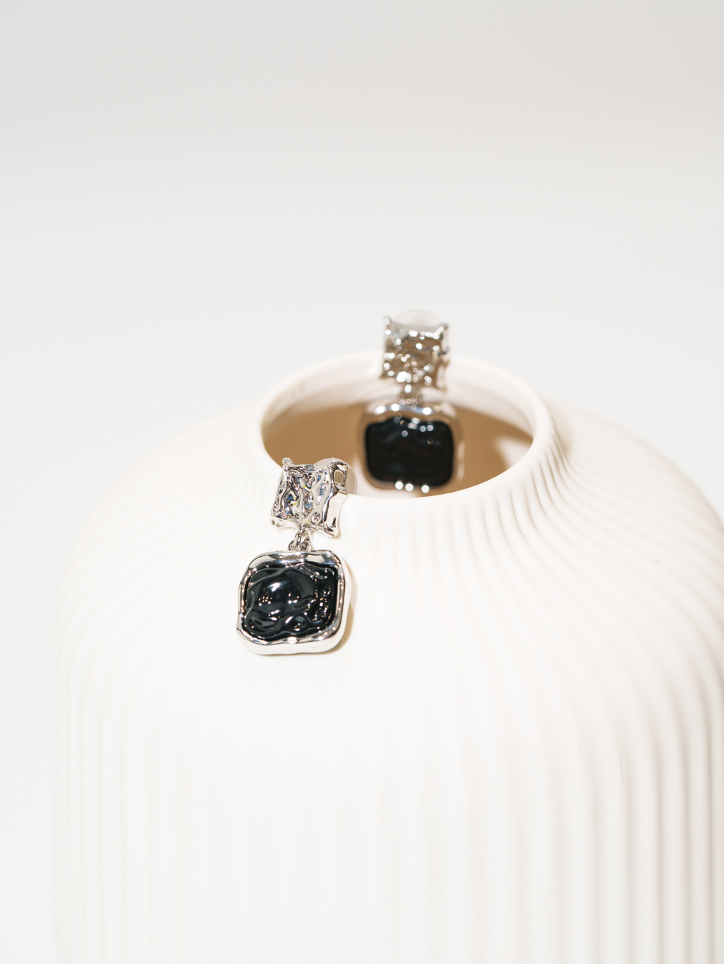 Лаконичные серьги из коллекции из металла серебряного и черного цвета объединяют геометрические формы и фантазийную фактуру. Украшение прекрасно дополняет практически любой стиль одежды и комплектуется с другими аксессуарами. Фурнитура выполнена из гипоаллергенного сплава со стойким гальваническим покрытием. Длина серег составляет 3 см, вес - 9 граммов.