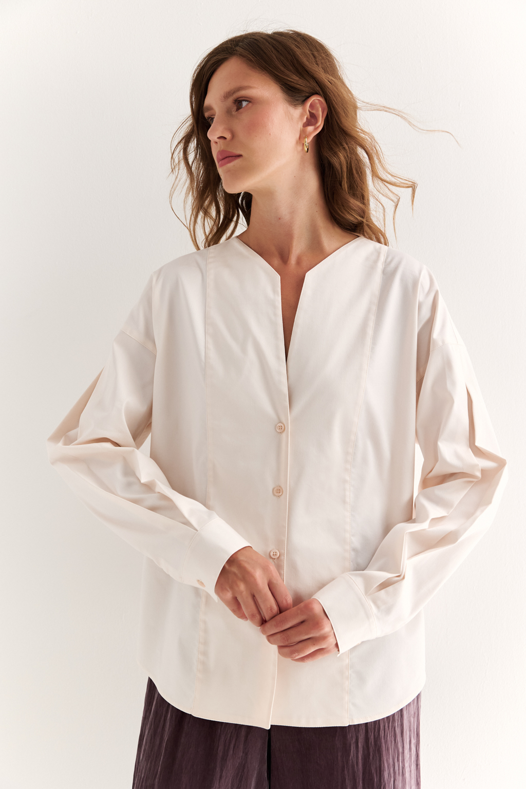 Блуза с V-вырезом: нежность в современном ритме. Эта блуза сочетает в себе деликатность форм и продуманную простоту. Глубокий V-образный вырез визуально вытягивает силуэт, а мягкие линии кокетки и рукавов добавляют романтичности. Объёмные рукава с манжетами и аккуратная застёжка на пуговицы завершают образ с лёгкой винтажной ноткой. Идеально смотрится в паре с юбками на высокой талии, широкими брюками или под жилет. Благодаря универсальному дизайну легко вписывается как в деловой, так и в вечерний гардероб. Лёгкость, которая подчёркивает внутреннюю силу.