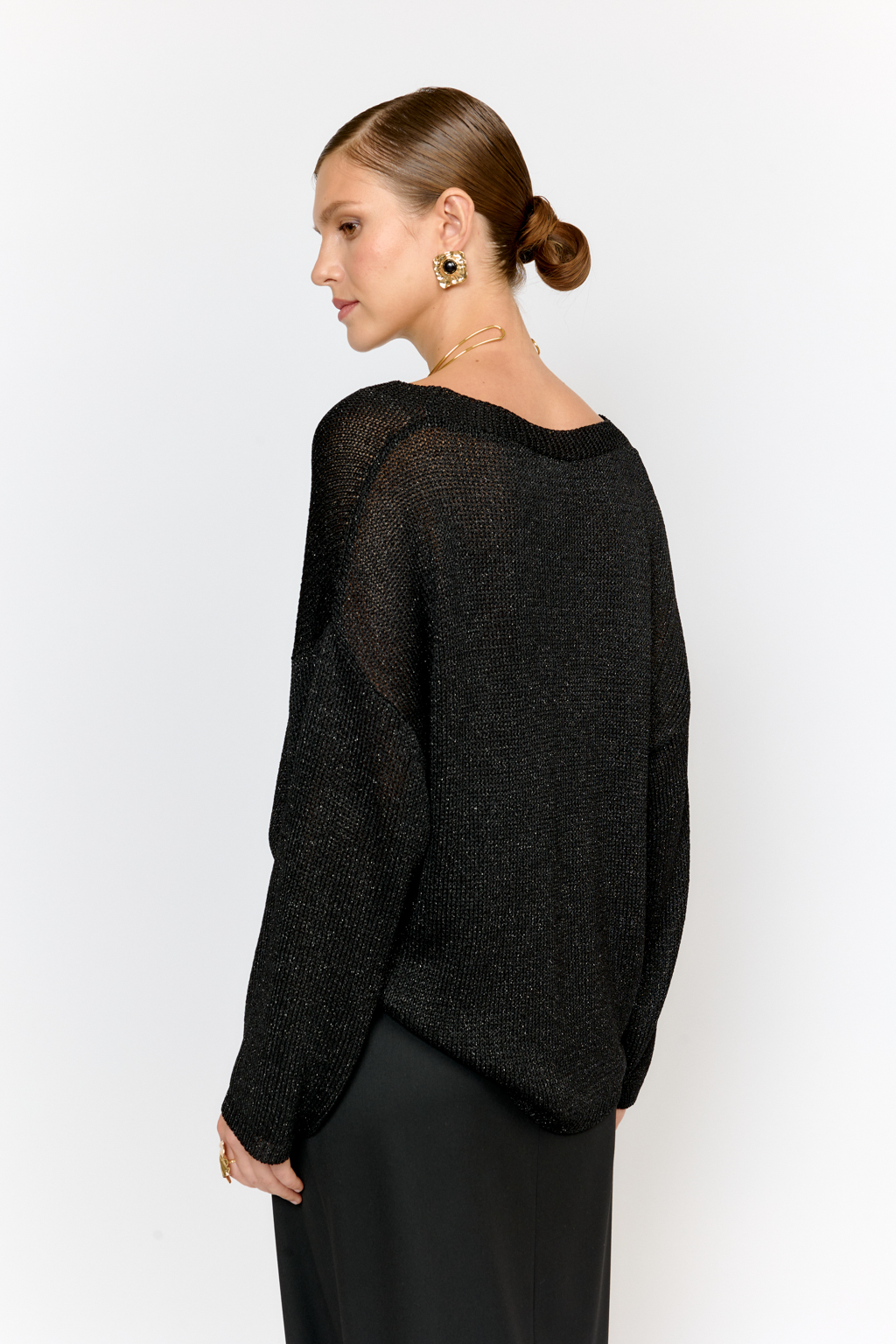 Модель джемпера с V-образным  вырезом горловины и свободным кроем выполнена из премиальной пряжи с вискозой в составе. Металлизированное волокно придает пряже  мерцание. Мягкие ниспадающие линии джемпера красиво драпируют фигуру. Базовая по крою модель, выглядит уникальной благодаря эффектному металлизированному блеску и глубокому черному цвету.  Элегантный силуэт с длиной выше бедер и изящным V-образным вырезом подчеркивает женственность и создает безупречный образ.  Универсальный силуэт модели в сочетании с базовым цветом позволит легко вписать джемпер в любой гардероб.