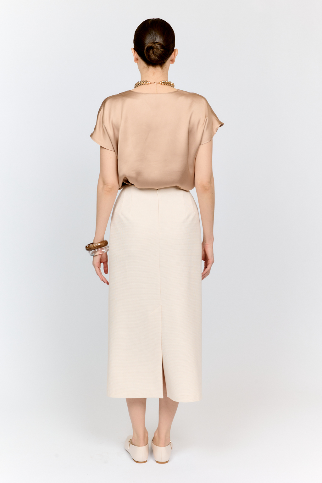 Топ с v-образным вырезом горловины из струящейся и переливающейся вискозы песочного цвета со спущенной линией плеча - отличная база для множества комплектов.