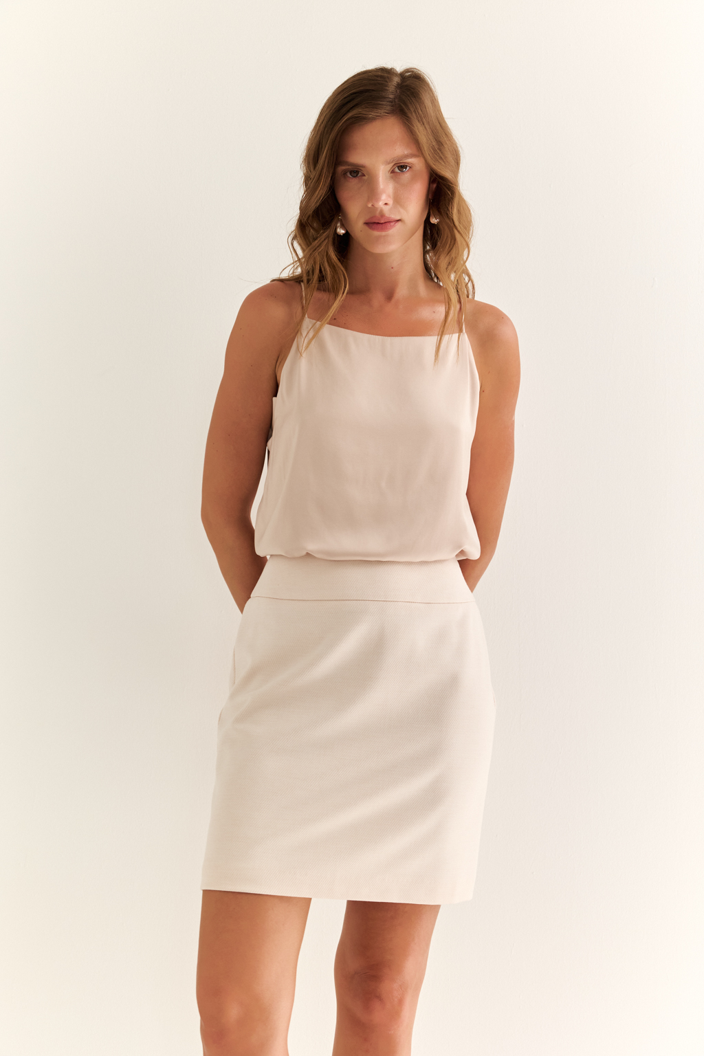 Мини-юбка - базовая вещь с максимальным потенциалом. Мини-юбка лаконичного кроя — это чистый холст для вашего стиля. Посадка на талии, чёткие вытачки и гладкий пояс обеспечивают идеальную посадку и подчёркивают силуэт. Застёжка сзади сохраняет чистоту линии спереди, делая образ особенно аккуратным и минималистичным. Идеальна для сочетания с жакетом в стиле Chanel, объёмными рубашками или базовыми футболками. Носите с каблуками или грубыми ботинками — в зависимости от настроения. Минимализм, который работает на вас.