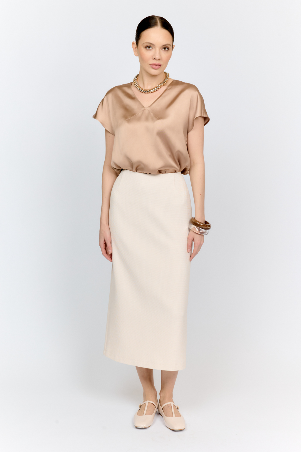 Топ с v-образным вырезом горловины из струящейся и переливающейся вискозы песочного цвета со спущенной линией плеча - отличная база для множества комплектов.