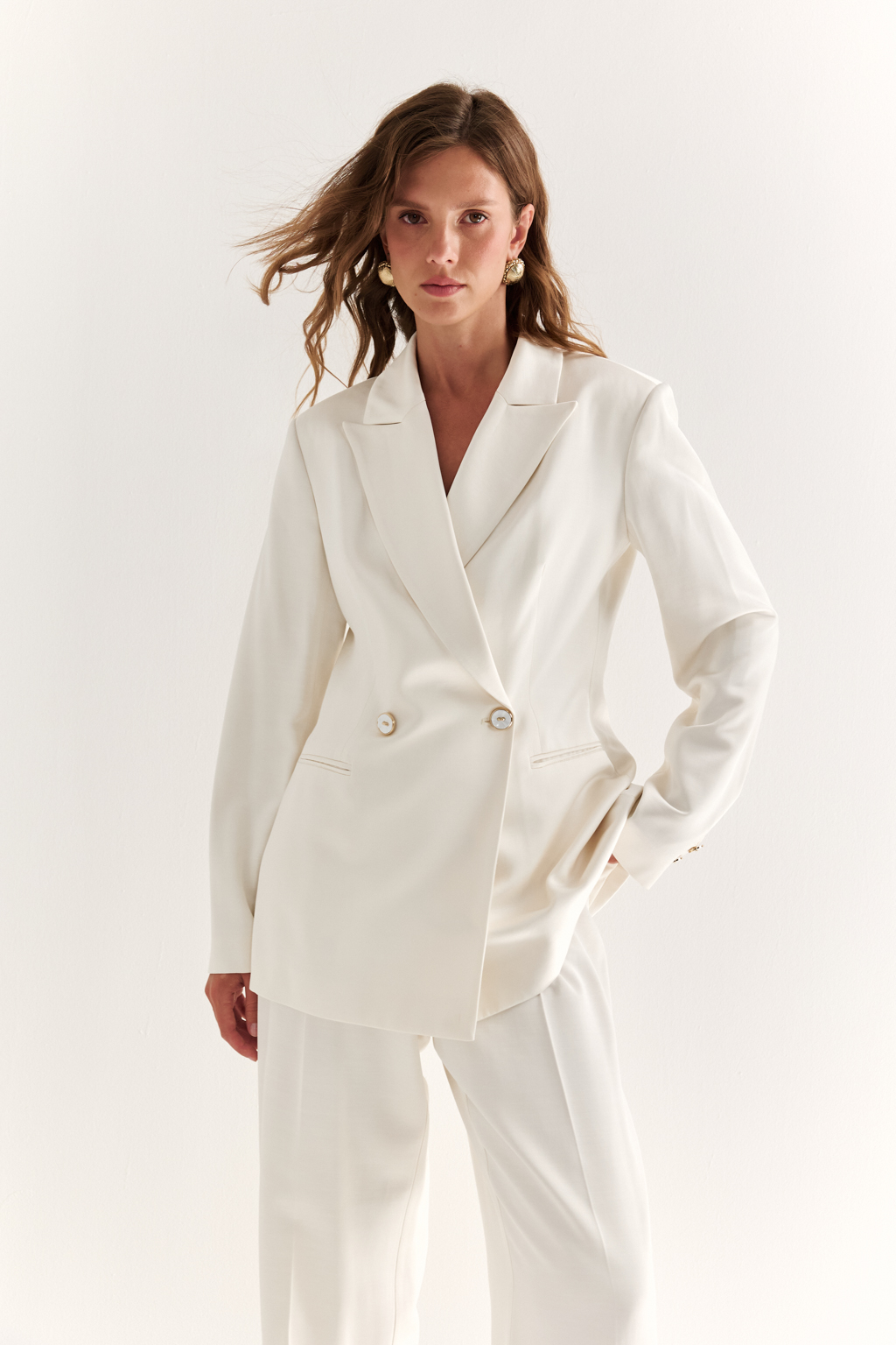 Двубортный жакет: классика в современной геометрии. Удлинённый двубортный жакет — это база, которая говорит о статусе без слов. Чёткие плечи, графичный крой и острые лацканы формируют уверенный, собранный образ. Рельефы по спинке и бокам подчёркивают силуэт, обеспечивая идеальную посадку, а карманы добавляют практичности и сдержанного акцента. Идеален в паре с классическими брюками, юбкой-карандашом или джинсами. Работает как в деловом комплекте, так и в вечерней стилизации. Современная структура с уважением к традиции.