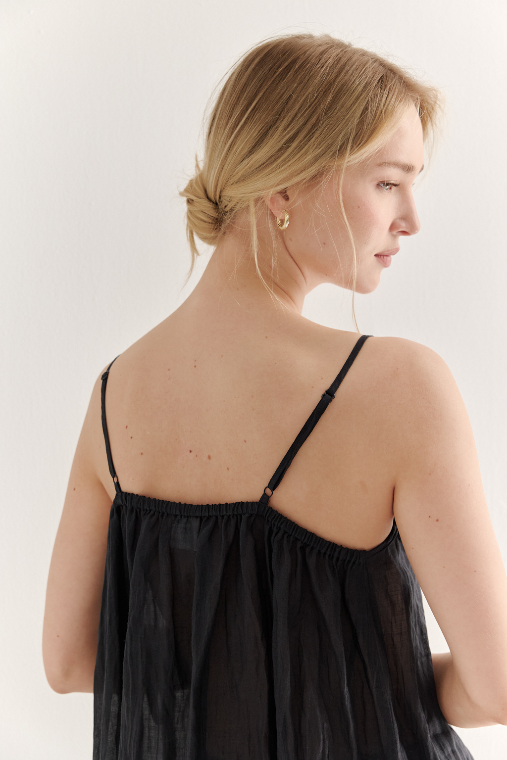 Топ-трапеция, выполненный из стопроцентной крапивы с крэш эффектом в черном цвете, украшен отделкой из кружевного гипюра в тон основной ткани. Кружевная деталь изысканно располагается на передней части изделия. Деталь переда топа настрочены на кружево со сборкой, по верхнему срезу спинки предусмотрена резинка, обеспечивающая оптимальную посадку. Бретели топа регулируются. Топ представляет собой идеальный комплект с брюками из крапивы, льна или хлопка, создавая гармоничный и стильный образ. Хранить в свернутом состоянии.