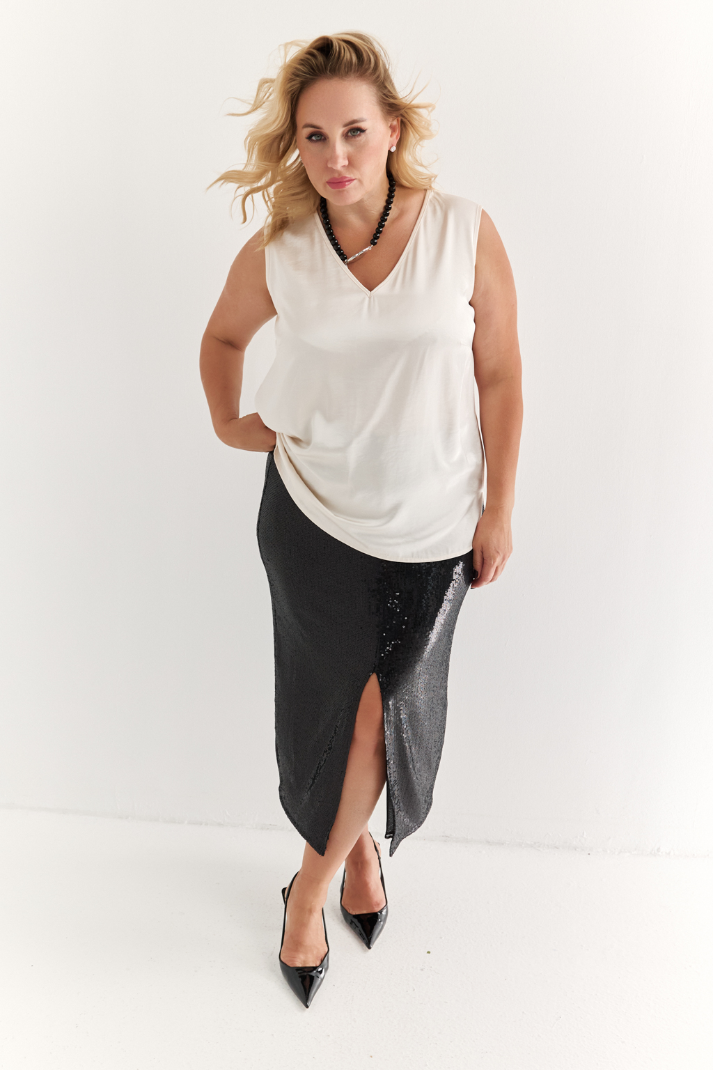 Силуэтная юбка длины миди с разрезом спереди из эластичной ткани с крупными мерцающими пайетками. Полиэстер практичен в уходе, держит форму и устойчив к сминанию. Преимущества ткани: умеренно блестящая, привлекающая  внимание ткань, для создания  эффектных образов. Пайетки придают изделиям уникальный блеск и сияние, делая их запоминающимися и праздничными. Основа  - мягкая пластичная сетка, что делает изделие комфортным.