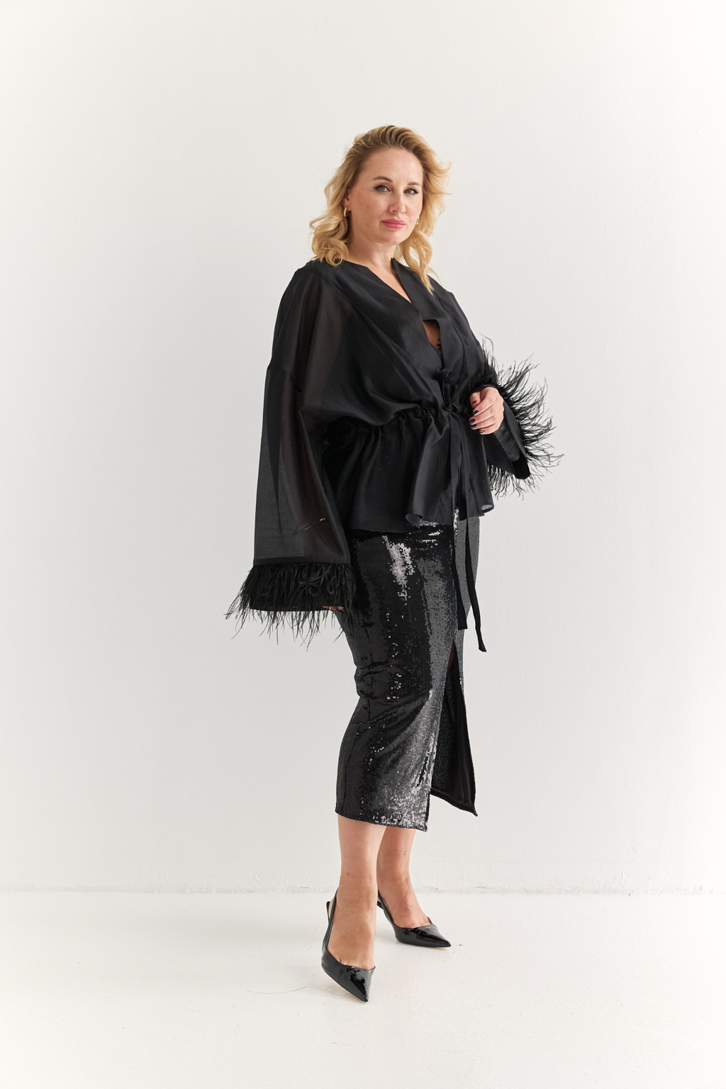 Силуэтная юбка длины миди с разрезом спереди из эластичной ткани с крупными мерцающими пайетками. Полиэстер практичен в уходе, держит форму и устойчив к сминанию. Преимущества ткани: умеренно блестящая, привлекающая  внимание ткань, для создания  эффектных образов. Пайетки придают изделиям уникальный блеск и сияние, делая их запоминающимися и праздничными. Основа  - мягкая пластичная сетка, что делает изделие комфортным.