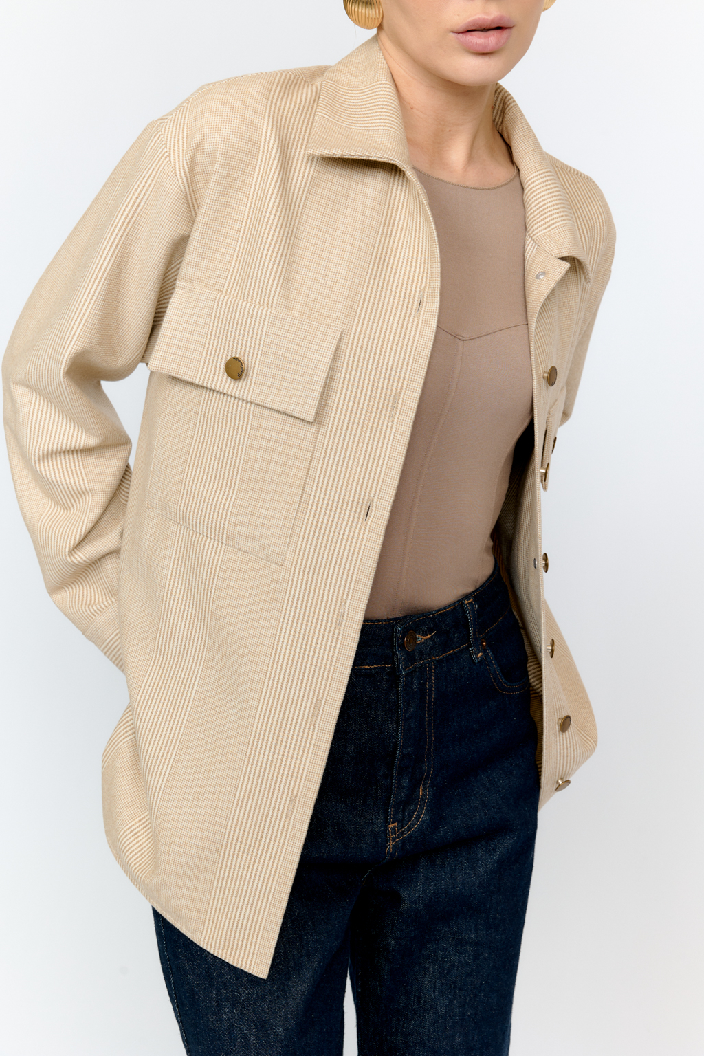 Рубашка свободного кроя с накладными карманами и застежкой на металлические пуговицы-болты из клетчатой костюмной ткани с peach-эффектом идеальна как для многослойных образов с футболками и водолазками, так и в качестве самостоятельной единицы.