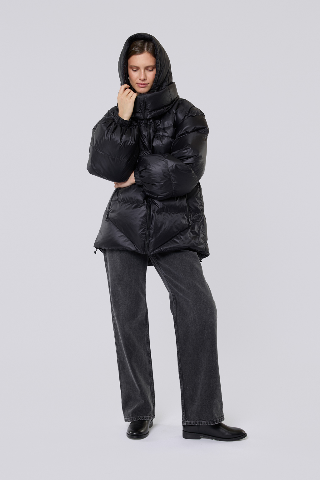 Прямой свободный пуховик на подкладке. Высокий воротник и копюшон обеспечивает дополнительную защиту от мороза и холода.