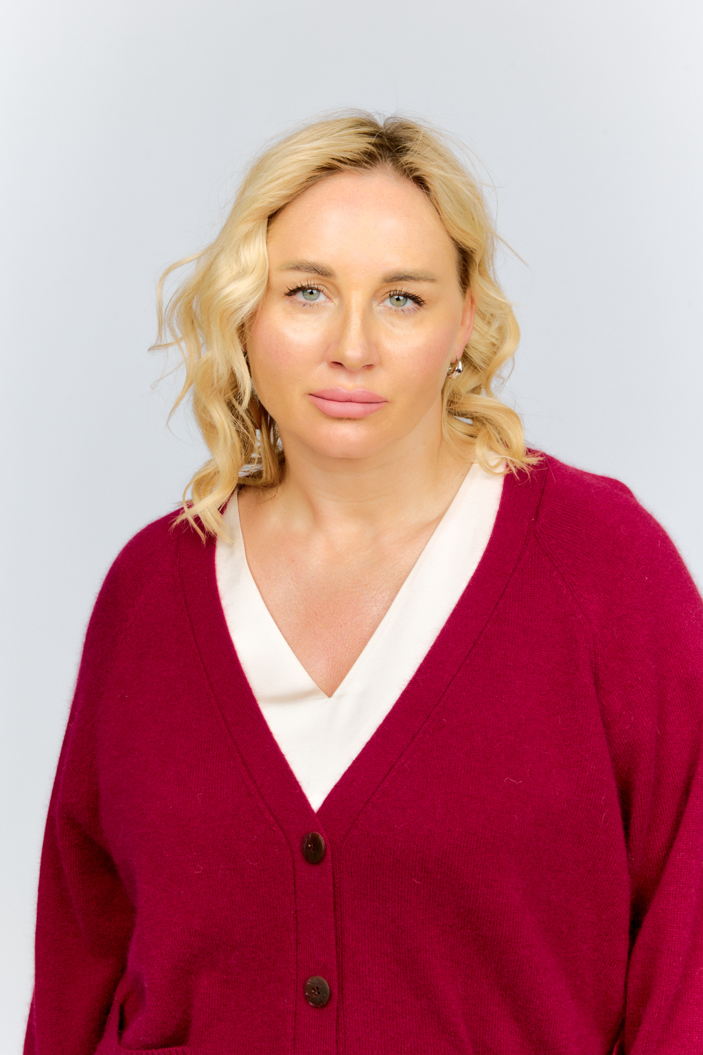 Кардиган прямого силуэта с V-образным вырезом и двумя накладными карманами. Застежка на пуговицах.