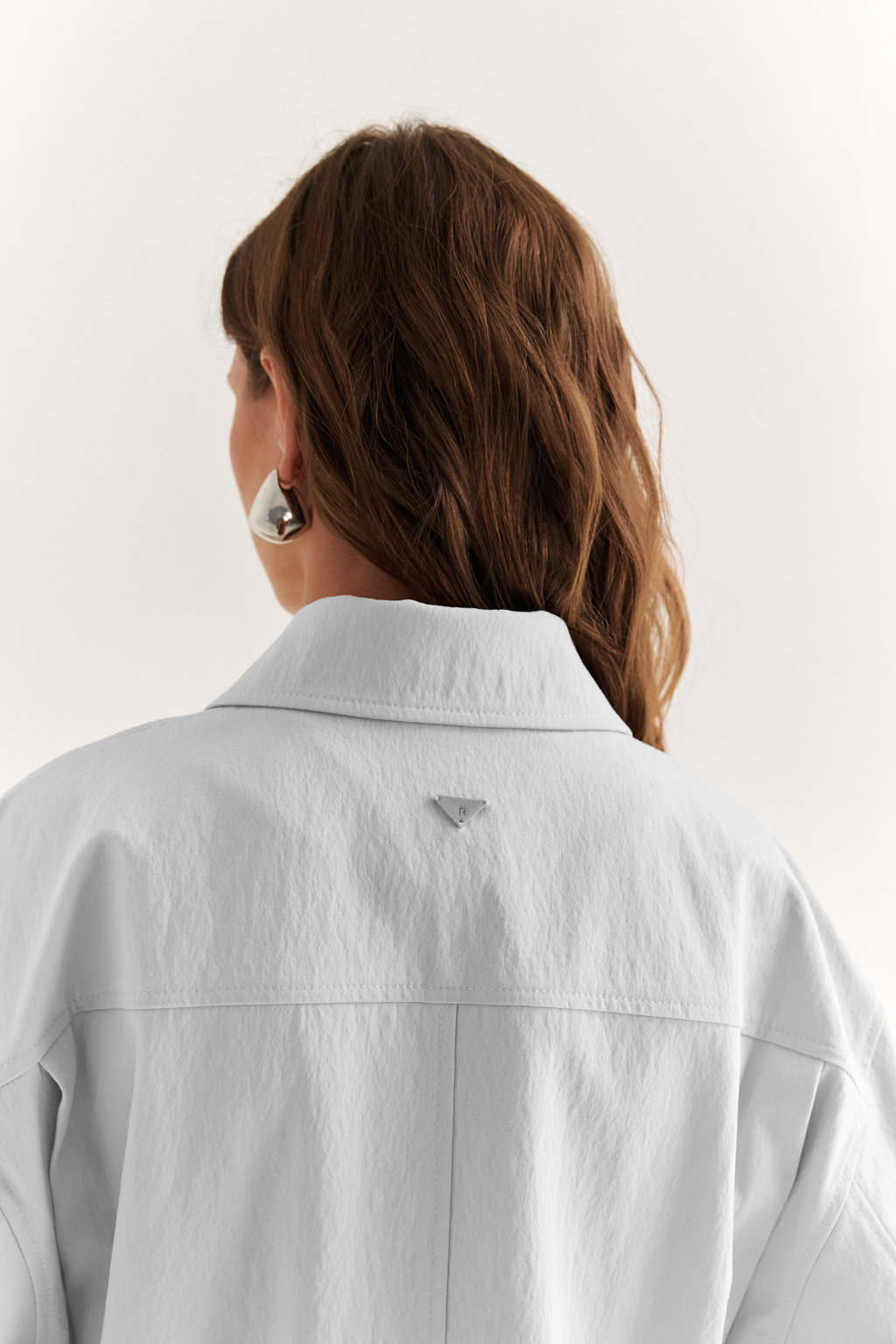 Куртка прямого силуэта длиной до бедер и с кулисой по талии. Воротник рубашечный, застежка под планкой. По полочке накладные карманы-портфели.