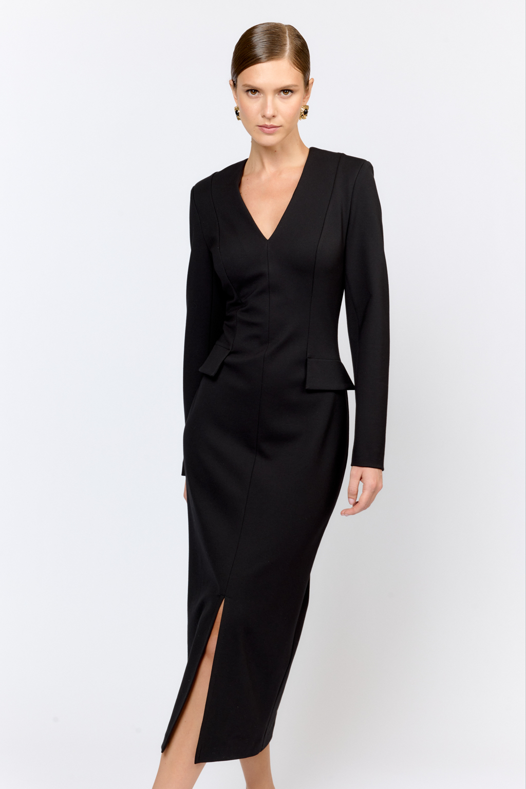 Платье для элегантных образов идеально впишется как в праздничный, так и в будничный гардероб благодаря лаконичности, силуэту и длине. Модель приталенного кроя прилегающего силуэта с глубоким V-образным вырезом и декоративными клапанами создающим эффект баски. Выполнено из плотной трикотажной ткани с содержанием вискозы. Вискоза делает ткань приятной к телу, обеспечивает воздухопроницаемость и пластичность. Нейлон  обеспечивает  износостойкость и стабильность насыщенного цвета.  Преимущества ткани: ткань хорошо держит форму, мягко облегая фигуру.  Не сминается, не требует особого ухода.   Позволяет коже "дышать".