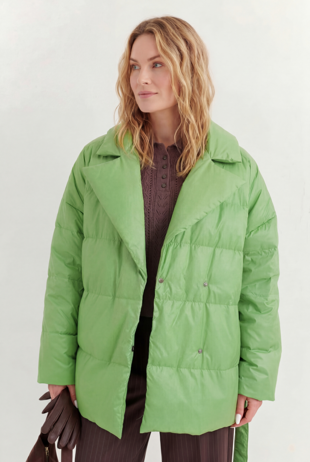 Короткий стеганый пуховик с английским воротником в цвете зеленой мяты, застегивается на кнопки, имеет регулируемый пояс, что позволяет носить изделие в разных вариациях.